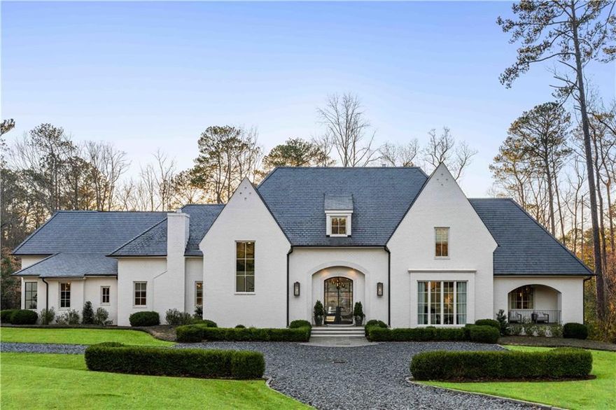 Rare opportunity!  This stunning custom-built home is located in desirable Buckhead, set on a 2.3 acre flat lot with picturesque views of a neighboring lake. The main level features a luxurious primary bedroom with floor to ceiling windows, a spacious primary bathroom and a large his/her closet. This desirable open concept layout with impressive chef's kitchen, complete with double islands, marble countertops, and top-of-the-line appliances.  Fabulous scullery off of the kitchen ideal when entertaining. The kitchen overlooks the family room and seamlessly connects to a covered porch, walk out backyard and swimming pool. The main level also features two separate offices and front and back staircases enhance accessibility.
Upstairs are three additional spacious bedrooms each with en suite bathrooms and generous closets. A second laundry room on the upper level adds convenience, along with a fantastic bonus TV area for family to enjoy. 
The lower level includes a media room and an exercise room. Incredible options for pickle ball court are right outside the terrace level door. 
The main level offers breathtaking sunset views over the backyard and lake, making this home truly one-of-a-kind and not to be missed.