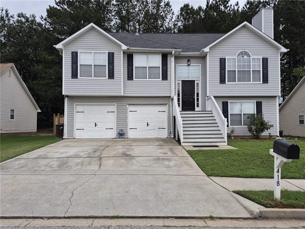 Gray siding exterior with white trim, featuring a prominent front staircase leading to the main entry
