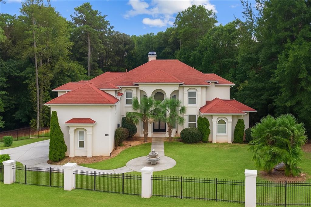 Prime location! Rare opportunity in Fayette County! There is no competition when it comes to this custom Mediterranean style estate home in the beautiful gated well maintained Legacy Hills Community. This resort-like oasis comes with all the bells and whistles: professional landscaping featuring palm trees, in-ground pool, jacuzzi for chilly evenings or relaxing refreshing nights, outdoor kitchen, 2 balconies, and a custom basketball court. This beauty sits on a corner lot and is in the cul de sac to give you the privacy you can appreciate. It has a grand entrance that opens up to views of the 1.2 acre lot. The great room is complete with a double sided fireplace and hugh windows showcasing tranquil views and natural light. The owner's suite is located on the main level and features a fireplace and private balcony with backyard views. Enjoy the classy and newly renovated primary bathroom that has a separate garden tub and an over-sized shower with must see special features, double vanities, and his and her walk-in closets. You will appreciate the office or nursery right outside primary suite for your convenience. The main level has a keeping room and sunroom with access to another balcony that allows you to enjoy breakfast or fancy dinners. Upstairs is loaded with 5 spacious bedrooms including an oversized teen/guest suite displaying a walk-in closet. This layout flows seamlessly into the basement which offers a huge theater room with 12-plus seating, bring your pool table and other games to create a very entertaining recreational area, room for a fish tank, and feel free to display pictures and trophies or your own personal hall of fame, work out in a space for an office and studio set-up. You are minutes from the Hartsfield Jackson International airport, restaurants, and shopping. Trilith Studios is also in the close vicinity offering food and entertainment and it is conveniently located to Woodward Academy and the interstate. *** This property is also listed for sale***.