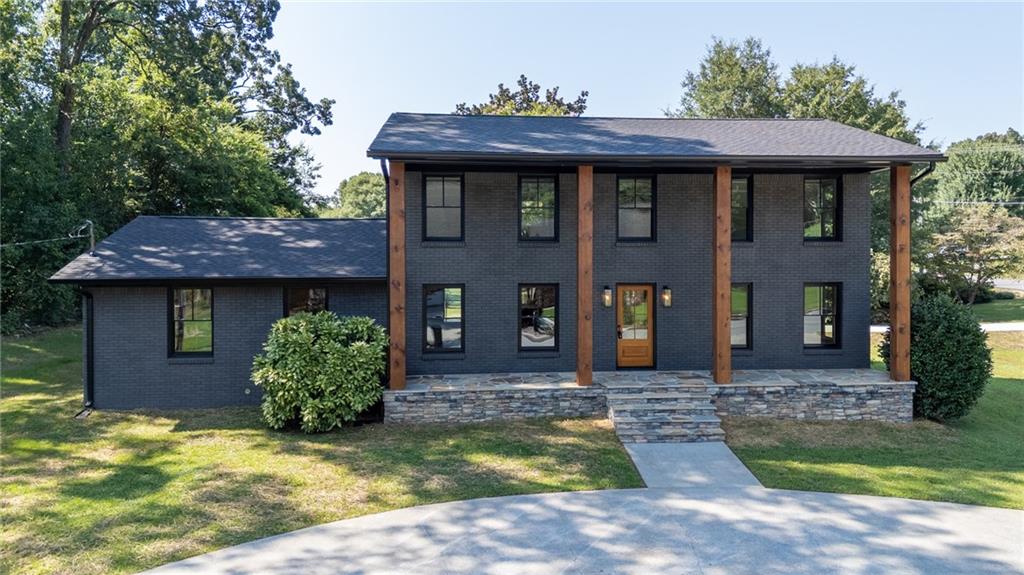 An originally designed 1966 home has been beautifully transformed with a modern renovation that perfectly blends the classic traditional charm with modern elegance. The exterior makes an immediate statement with a rich color palette, stone porches, tongue and groove ceilings, new insulated windows and a new architectural shingle roof. Inside this striking home, the family room is anchored with a stacked stone wall and wood-burning fireplace. The kitchen is the heart of the home and offers an adjoining breakfast nook or keeping room. Handsome custom-built cabinetry mingle with remarkable details, such as the soft close doors and drawers and a soft black center island paired with a modern stained wall cabinetry. The expansive primary bedroom wing, on the main level, can accommodate all your needs. There are walk-in his and her closets and impressive floor to ceiling tile in the luxurious primary bath. In addition, there is easy access to the laundry room from one of the primary closets. Four bedrooms and 2-bathrooms complete the upper level. One bedroom is suitable for play room or a separate gathering space. Throughout the home, luxury vinyl plank provides timeless durability. The bathrooms are fitted with bold Kohler designs. Every update, from the new HVAC units to the carefully selected finishes, enhance the style and appeal. This is a great entertaining and family home!