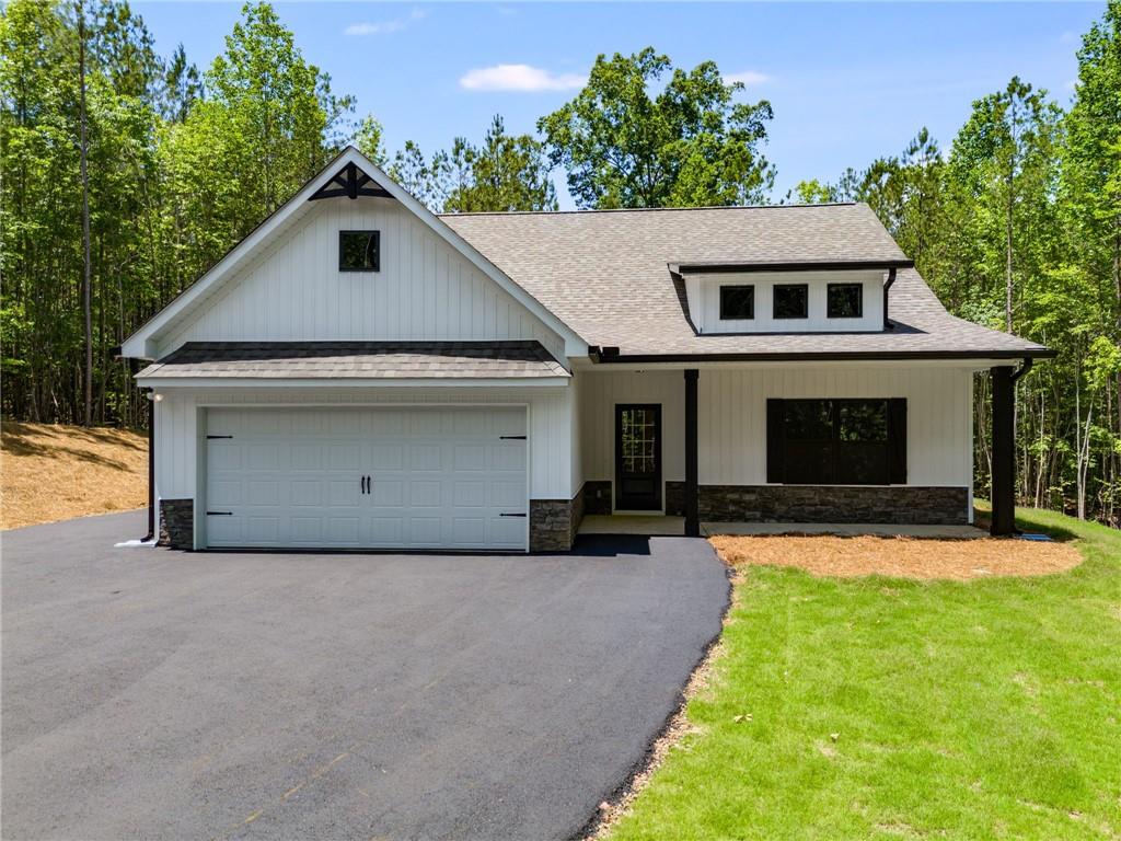 Construction to begin soon! Seize the chance to own your own PRIVATE 10 ACRE lot! This stunning NEW step-less craftsman-style RANCH is designed with modern living in mind! The open floor plan features a vaulted family room with a custom shiplap fireplace. The gourmet kitchen has an oversized ISLAND that is perfect for entertaining & features a charming FARMHOUSE sink. You'll also appreciate the convenience of a separate laundry room & an OVERSIZED PANTRY, providing ample storage and functionality. Every detail exudes luxury and style, making this home inviting and practical. The Gourmet kitchen showcases a CUSTOM ISLAND, FARMHOUSE SINK, STAINLESS APPLIANCES, shaker CABINETS, GRANITE COUNTERTOPS & HUGE PANTRY. The primary suite offers a luxurious ensuite bath with a breathtaking TILE SHOWER & custom glass door, plus a large walk-in closet. Two generous secondary bedrooms provide ample storage with large closets, complemented by a stylish full bathroom. Relax on your picturesque front porch while overlooking your private tree-lined view. The oversized covered back porch is the perfect spot for relaxing & entertaining and features a custom wood-burning OUTDOOR FIREPLACE. This gorgeous modern farmhouse style will include BLACK exterior WINDOWS! Standard features include beautiful exterior vinyl siding, luxury LVP in the kitchen, living room, entry, and baths; plush carpeting in the bedrooms; and high-quality finishes throughout. Enjoy the freedom of a PRIVATE LOT with no HOA restrictions, combining tranquility with convenient access. You still have time to choose your interior and exterior colors to make this home your dream! Not quite the right floor plan or lot? We have other lots and floor plans available! Be sure to inquire about incentives by utilizing our lender, Gareth Thomas, at Silverton Mortgage. Photos are not of the actual home but represent this plan (lot/drone pictures are of the lot).