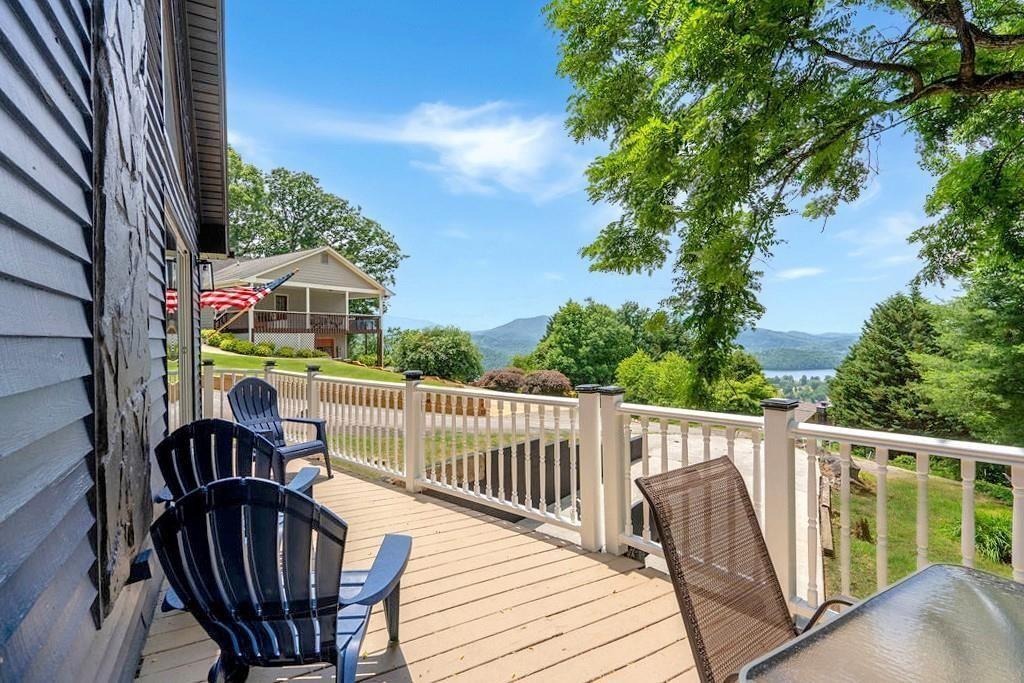 Priced below recent appraisal. Escape to your very own mountain paradise! This beautifully remodeled, fully furnished 3-bedroom, 2.5-bathroom home sits atop a picturesque mountain, offering breathtaking, panoramic views of Lake Chatuge and the Blue Ridge Mountains. From top to bottom, every detail of this home has been thoughtfully designed to maximize comfort and showcase the natural beauty of the surrounding landscape. The main level greets you with an abundance of natural light and an open-concept floor plan that allows you to fully enjoy the awe-inspiring views of the lake and mountains. The spacious kitchen is a chef's dream, offering plenty of counter space, bar seating, and an additional coffee bar area — perfect for enjoying your morning coffee while taking in the serene surroundings. The king-sized owner’s suite is a true retreat, featuring a completely remodeled bathroom with high-end finishes and plenty of space for relaxation. Upstairs, a cozy bedroom with ample closet space offers even more sweeping views of the lake and mountains. The lower level of the home provides a fantastic bonus living area, complete with a bedroom featuring dual closets, a full-size bathroom/laundry room, and a convenient drive-under, single-car garage. Step outside and embrace the beauty of nature. Whether you're relaxing on the deck, soaking in the hot tub, or enjoying the newly designed fireplace area, this home offers multiple outdoor spaces where you can unwind and take in the stunning views. This home is the perfect getaway for entertaining guests or simply enjoying quiet moments, offering a captivating escape with nature.