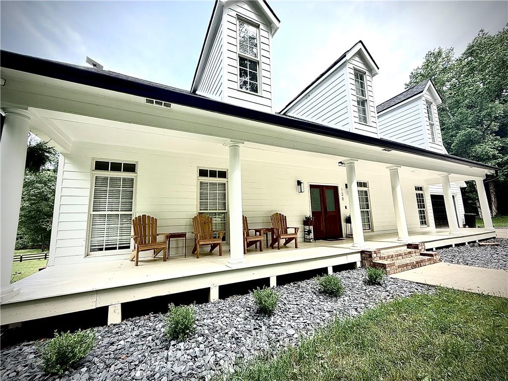 Southern Living at Its Finest in the Towne Lake Area of Woodstock. This beautifully renovated estate home offers 5 bedrooms and 4.5 baths with 6000 sq ft of fully finished living space, plus an additional 1,500 sq ft of unfinished space for storage or future expansion, nestled on over 5 acres of private land—bring your horses! Every inch of this home has been thoughtfully updated from top to bottom, blending contemporary design with rustic charm. Step inside to an open-concept layout filled with natural light. The chef’s kitchen boasts quartz countertops, a brick backsplash, white shaker cabinetry, and a spacious island with a large sink overlooking the family room. The family room features a striking brick fireplace with a cedar mantle, and a wall of windows opens to French doors leading out to a massive deck—perfect for morning coffee or entertaining guests. The oversized primary suite offers a peaceful retreat with a spacious walk-in closet and a luxurious en-suite bath featuring double vanities and a large tile shower. Upstairs, you’ll find a full in-law suite complete with two oversized guest bedrooms, a full bathroom, additional laundry, and a private living room. The bonus room over the garage provides the ideal space for a home office or playroom. The fully finished basement includes a home gym with a spa-like bathroom, a second living area with another brick fireplace. Outside, enjoy professionally landscaped grounds, a black-painted fence, a tractor barn, garden area, and open pasture. All just 1 mile from Publix, 2 miles from Lake Allatoona, and minutes from downtown Woodstock. This is the perfect blend of privacy, convenience, and timeless Southern charm.
