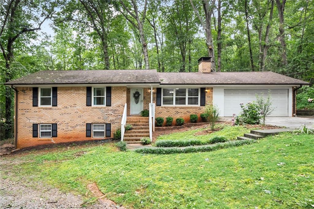 Charming 4 Side Brick Ranch nestled on a beautiful, wooded lot in a quiet Cumming neighborhood just .3 miles from Cumming City Center. Nestled up to a 20+ acre Conservation Tract, the property provides exceptional privacy and the feel of country living while still being in the heart of town. Recently updated with new granite countertops, new oven, new water heater, new master vanity & light fixtures, all new interior doors, new lighting, fresh paint, and new carpet throughout the main level. The full basement features a side daylight private entrance offering a recently remodeled income-generating 1 bedroom/1 bath apartment with a full kitchen, LVP flooring throughout, and private laundry access. The basement also hosts a workshop/storage area and an unfinished family room with a brick fireplace, with potential to finish an additional 500+ living space. Enjoy the large fenced-in backyard while relaxing on the screened-in porch and enjoying the abundant natural light from the many windows. Plenty of parking with a recently enclosed two-car garage, oversized driveway, and gravel drive to lower-level apartment. With no rental restrictions, this property presents an excellent opportunity for investors in a highly sought-after location for two potential rentals in one property. With a welcoming front yard and thoughtful updates, this home is priced to sell—don’t miss your opportunity!