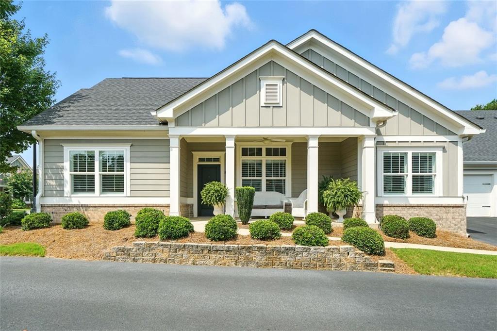 Stunning ranch condo is in the heart the of Hickory Flat area of Woodstock. You will feel right at home the moment you enter this flowing open floor plan. This home has been meticulously maintained and upgraded with no details left out. The great room is open to the dining area and the gorgeous kitchen. Quartz counters, gleaming white back splash with under cabinet lighting grace the fabulous white kitchen cabinets with custom pull out shelves. Gas cooktop, electric wall oven, microwave and pantry finish out this cook's dream. The breakfast bar has ample seating area and views the keeping room which will be your favorite spot to visit. Designer light fixtures grace each room. Owners suite on main has trey ceilings and a wonderful spa bath with marble counters. The amount of space in the closets will amaze you.Secondary bedroom is spacious and its bath has a tub/ shower combination with frameless custom door, marble vanity and a linen closet. The flex room makes a great den or office. There are lovely hardwood floors on the entire house except for tile in the baths and laundry room.Laundry room has custom cabinets & a quartz folding counter. Plantation shutters grace every window. Permanent stairs to the attic lead to a partially climate controlled storage/ flex room. Garage floor is tiled and has additional storage. Sit out on the front porch and enjoy this great condo community with sidewalks, a clubhouse and salt water pool. This active 55+ community has social activities. It is also in walking distance to the Hickory Flat library, grocery store, restaurants and more. You don't want to miss out on seeing this one. Welcome home.