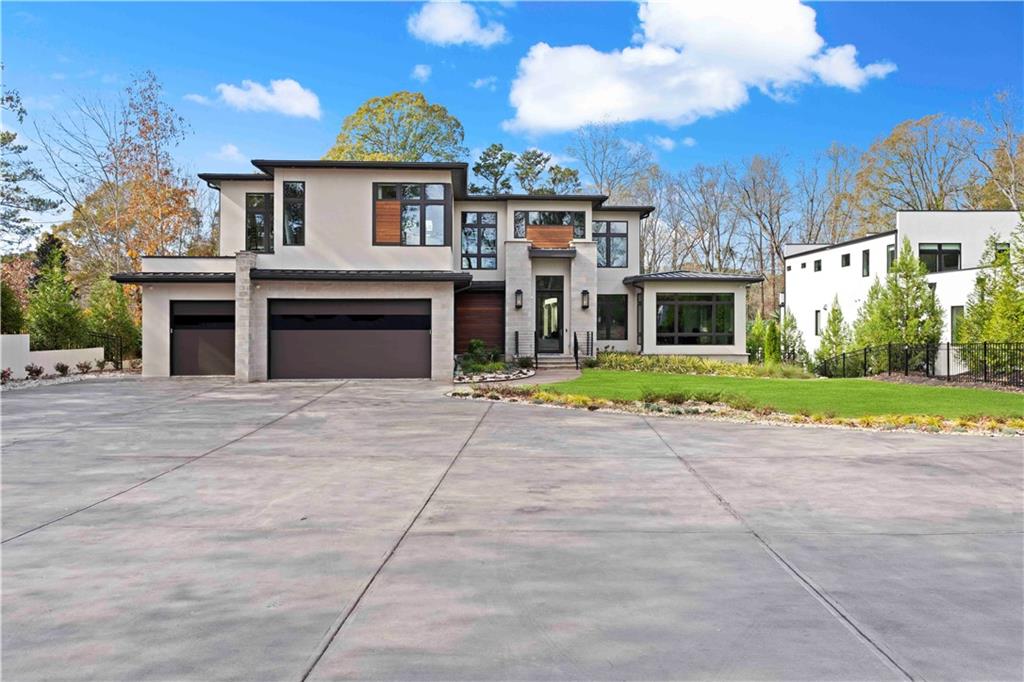 Feast your eyes upon the most magnificent modern estate in Buckhead! Extraordinarily designed, and custom built by Bella Fine Homes, this gated home boasts 5 beds, 5 full baths and 3 half baths, with an open concept floor plan featuring 20+ feet ceilings and gorgeous white oak hardwood flooring throughout. Floor-to-ceiling tinted windows offering boundless natural light, with automated shades for your privacy. Chef's kitchen with Miele appliances, built-in espresso machine and 4 range and steam ovens. Fully automated URC Smart Home Control and security system with cameras. 16 ft accordion doors that open to the ultimate resort style, astroturfed backyard oasis! Entertain with ease in your salt water, infinity-edged pool, covered fire pit, outdoor kitchen & grilling station w/beverage center and a pool bath. So many intricate fine interior details - Owner's suite on main w/separate sitting room which accesses the outdoor features. Custom his & her closets w/locking jewelry drawers, a luxurious owner's bath with floating vanities and heated floors. A spacious 2nd story open loft space, expansive secondary en suite bedrooms, Sonos audio system, in-wall Ipad controls, Lutron accent lighting, an elevator, and an exquisitely finished terrace level featuring an open recreation area, media room, styling salon, kitchenette, office suite, fitness room and sauna/steam shower. 3 car garage w/ electric car charging port and ample parking space. Easy access to all major highways, Atlanta's top-rated public and private schools, shopping and fine dining. This all-encompassing, contemporary dream home has it all!