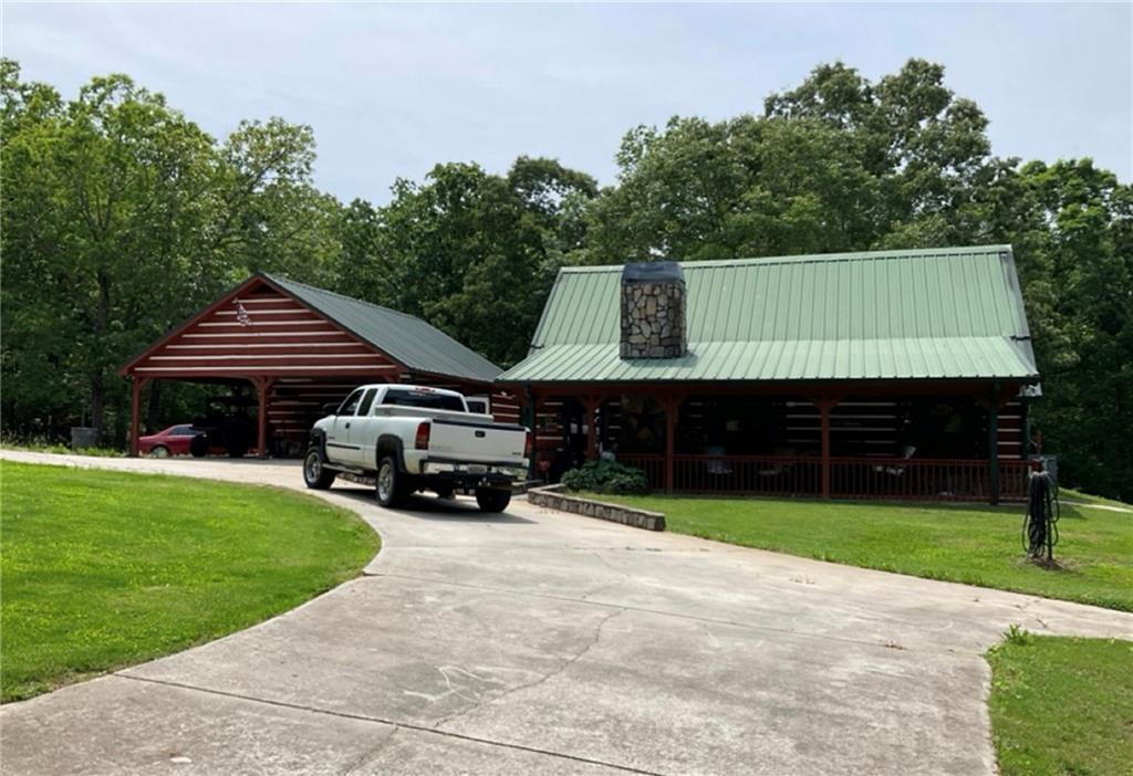Welcome to your own country paradise! This stunning 49.75-acre property offers a charming log cabin, a carport/ office, an in-ground saltwater pool, a pool house, an outdoor cooking shed, and a spacious 22x40 triple garage bay/ workshop. The land features mostly mature hardwoods with some pasture, providing the perfect setting for outdoor adventures. Enjoy the outdoors right on your property, or explore the ample space for ATVs, dirt bikes, and 4-wheelers. Create your own trails or ride along the existing ones. The cozy home has all the looks of a real log cabin, but is not built with real logs! This makes for simpler construction, better insulation and easier maintenance. The home boasts 2 bedrooms on the main floor and an additional bedroom adjacent to a loft area. The open kitchen flows seamlessly into the living room, complete with stone trim around the bar. The living room is highlighted by high vaulted ceilings with beautiful beams, a stone fireplace, and a striking stone archway that leads to the hallway and bedrooms. The master bath offers a whirlpool tub, separate shower, and laundry connection, while the large mudroom provides a perfect entrance after a day of outdoor activities. Along side of the in-ground saltwater pool is a unique matched pool house with a kitchenette. The adjacent carport has an attached office, offering flexibility for your needs. This property is not only ideal for personal recreation but also presents a great opportunity as a family compound or potential lot development. DonCOt miss the chance to see it for yourselfCocall today for a showing! Agents/ Buyers please see private comments for showing information. There is NO real estate yard sign per the owners request.