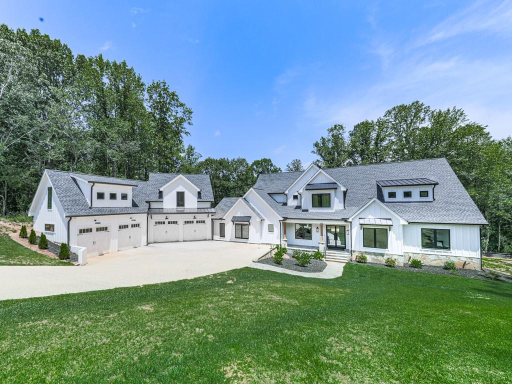 Welcome to your own slice of paradise! This exquisite custom modern farmhouse boasts a perfect blend of modern luxury and rustic charm. Step inside and be captivated by the soaring cathedral ceilings in the great room, featuring a cozy gas fireplace, Andersen stacking rear doors, and a built-in bookcase, all enhanced by a state-of-the-art SONOS sound system. Entertain effortlessly in the open-concept dining area with elegant built-in cabinetry, adjacent to a chef’s dream kitchen equipped with a premium Thermador appliance package to include: 48" Refrigerator, 48" Freezer, 24" Wine Cooler, 48" Range with pot-filler, built-in Double Ovens, and built-in Microwave Oven, Coffee Maker and Elkay water dispenser in the pantry. All of this and so much more! A spacious 12' island with bar-counter seating and additional storage, perfect for gatherings. A convenient butler’s pantry and walk-in pantry adds extra storage for all your culinary needs. The main floor hosts a luxurious primary suite, complete with a custom bathroom featuring double vanities, a soaking tub, and an expansive 14ft wide walk-in 9 shower heads on each end, along with a beautifully crafted walk-in closet. Need space for work? This home offers two dedicated home offices, ensuring productivity in a serene setting. With 6 bedrooms, 4.5 baths, and charming guest quarters on the main level, there's room for everyone. The upper-floor boasts 4 spacious bedrooms, providing ample space for family and guests. Enjoy the convenience of a beautifully designed hall bath and a practical Jack and Jill bath connecting two of the bedrooms, perfect for shared living. Plus, with a second dedicated laundry room, managing household chores is a breeze. Enjoy warm evenings on the oversized fireside deck, or take advantage of the recently finished 1000SF space above the detached 4-car garage—ideal for hobbies, a private studio, or future apartment. The unfinished basement is already 60% complete with HVAC, electrical, and insulation, ready for your personal touch. Plus, the generous backyard offers room for a pool, turning your outdoor dreams into reality. Explore every corner of this enchanting home from the comfort of your couch with our immersive 3D virtual tour, allowing you to envision life in this incredible space before you even set foot inside. Located in a friendly neighborhood with top-rated schools, parks, and convenient shopping nearby, this property is not just a house—it's a lifestyle. Don’t miss this rare opportunity to own a remarkable property that perfectly balances luxury living with the comforts of home. Schedule a viewing today and make this farmhouse your forever sanctuary!