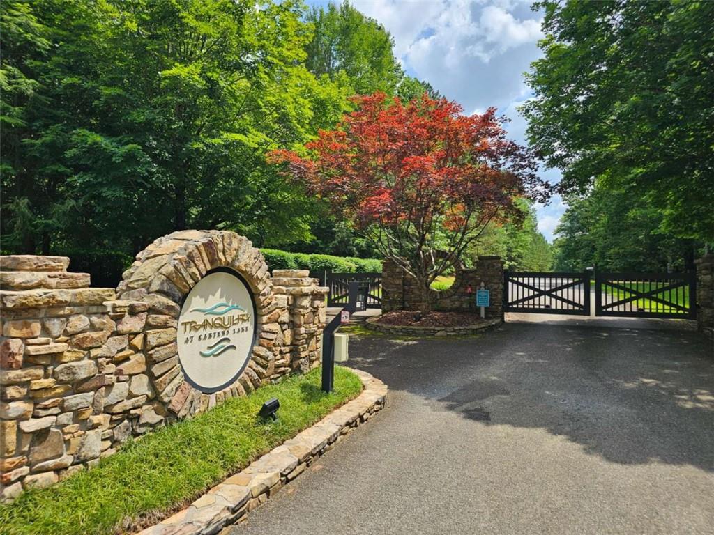 For those seeking higher end living and a serene escape... Are you ready to take the first step toward that dream home in the mountains, in a gated, wooded sanctuary just 70 miles north of Atlanta? Imagine building your perfect home in a mix of hardwoods and pines on a flat to slightly sloped, one-acre parcel in Tranquility at Carter's Lake, a prestigious planned community with paved roads, gated security, underground utilities, and public water. Whether you're: A luxury-minded buyer desiring exclusivity and custom design, a remote-professional or growing family craving space, privacy, and outdoor amenities, a weekend getaway seeker from the metro area wanting mountain and lake access, or a retiree or downsizer looking for low-maintenance living amidst nature ... this is tailored for you. Lot highlights include: A flat to slightly sloped, easily accessible building site along a quiet, paved road; A lush, wooded 1 acre canvas offering privacy and natural beauty (not just the lot, by the community as a whole); Gated entry, underground utilities, and meticulously maintained roads and landscaping. Community perks include: A gorgeous creekside park with playground, pavilion, picnic areas, walking trails, and creekside swings along Harris Creek 1/2 mile from lot); Just 5 minutes (1.5 miles) from Doll Mountain boat ramp and picnic area on Carter's Lake, Georgia's deepest reservoir with 3,200 acres of clear, deep water and 62 miles of shoreline. This lot truly offers the perfect setting for those who appreciate peace, privacy, and proximity to nature. Only 15 minutes to Ellijay, and the quaint mountain vibe the shopping and restaurants bring. Ellijay at large puts vineyards/wineries, hiking trails, biking trails, canoe and kayak within a half hour reach. Time to make take that step and make the call. 678-207-6888.