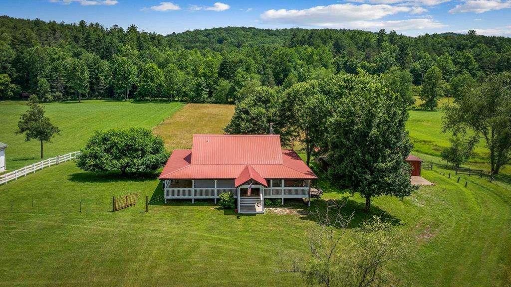Your North Georgia Farmstead Awaits Tucked in a quiet, rural corner of Fannin County and just 15 minutes from downtown Blue Ridge, this scenic 5-acre farm is where peace, privacy, and potential come together. Whether you're dreaming of starting a working farm, building your homestead, or creating a tranquil retreat for your horses, this property is the perfect canvas. The fully fenced land features a mature hay field ideal for grazing livestock or producing bales to store or sell. A small pond provides water for animals, and the pasture gently rolls down to a clear, year-round mountain stream-full of trout and framed by distant views of the Cohutta Mountains. The landscape is dotted with mature trees, including a graceful weeping willow and one of the most beautiful mulberry trees you'll ever find. The barn is meticulously maintained, offering 3-4 stalls (including a birthing stall), two tack rooms, and durable concrete floors-perfect for horses, goats, or other livestock. The rustic wood and log-style home features vaulted ceilings, a central stone fireplace, and large windows to take in the peaceful countryside. Covered porches on both the front and back offer the ideal spots to enjoy your morning coffee or relax after a day on the farm. The home offers solid craftsmanship and timeless charm, with room to make it your own through thoughtful updates or personal touches. Features include a tankless water heater and the potential to include select farming equipment with a solid offer. Located in an extremely quiet area with no light pollution, the night skies here are breathtaking-offering stargazing opportunities you won't find in town. And when you do need to head into town, the drive is easy and scenic, making this location both secluded and convenient. Just minutes from the Tennessee line this is truly one of the most beautiful slices of North Georgia. Bring your boots, your animals, and your vision-your Appalachian farm life begins here.
