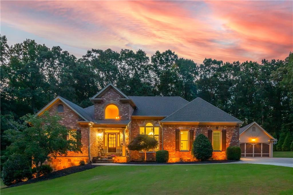 Welcome to 644 Herring Road, where life feels more like a private retreat than a suburban routine. Set on a private 3.15, unrestricted acres just 2 miles from downtown Grayson and only 6 miles from the heart of Lawrenceville in the popular Grayson high school district, this four-side brick estate offers the space, freedom, and flexibility today’s homeowner craves, with no HOA to limit what you can do. Whether you’re an avid entertainer, a car enthusiast, or a small business owner with work vehicles or tools that need a home base, the detached garage and expansive grounds give you the freedom to create, build, store, or unwind on your own terms. Imagine mornings spent sipping coffee beneath coffered ceilings on the covered patio overlooking the amazing backyard, afternoons grilling under the cabana by the saltwater pool, relaxing with a beverage by the firepit over conversation with friends, or unwinding in your private theater as the day winds down. With four bedrooms spread across two levels, including a main-level primary suite with poolside access, there’s space for guests, in-laws, or teens to have privacy without being far. There's also a big bonus room above the garage, and another big one in the basement. And with three major parks, multiple youth sports leagues, fishing lakes, and biking trails within a 10-minute drive, you’re never far from fun, yet always just far enough away to feel at peace. I-85 is a few miles away for easy commuting, and the nearby amenities in surrounding cities and counties offer everything from date night dining to daily errands without the long drive. More than a house, this is a lifestyle, where weekend projects, outdoor memories, and quiet luxury come together in one unforgettable address.