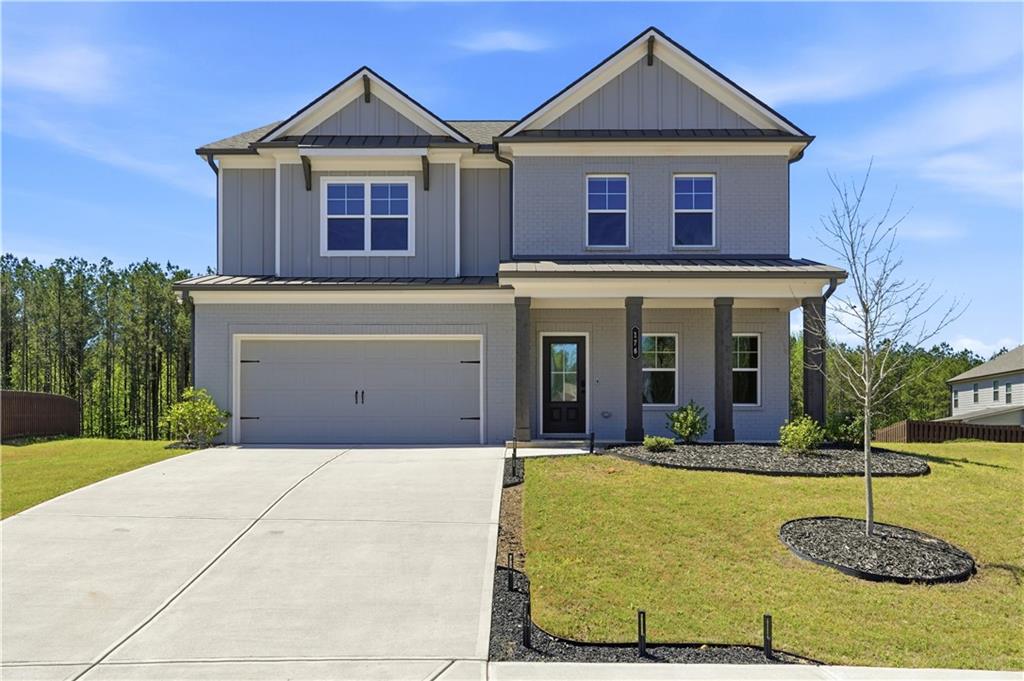 Craftsman-style home with a standing seam roof, a garage, board and batten siding, and covered porch