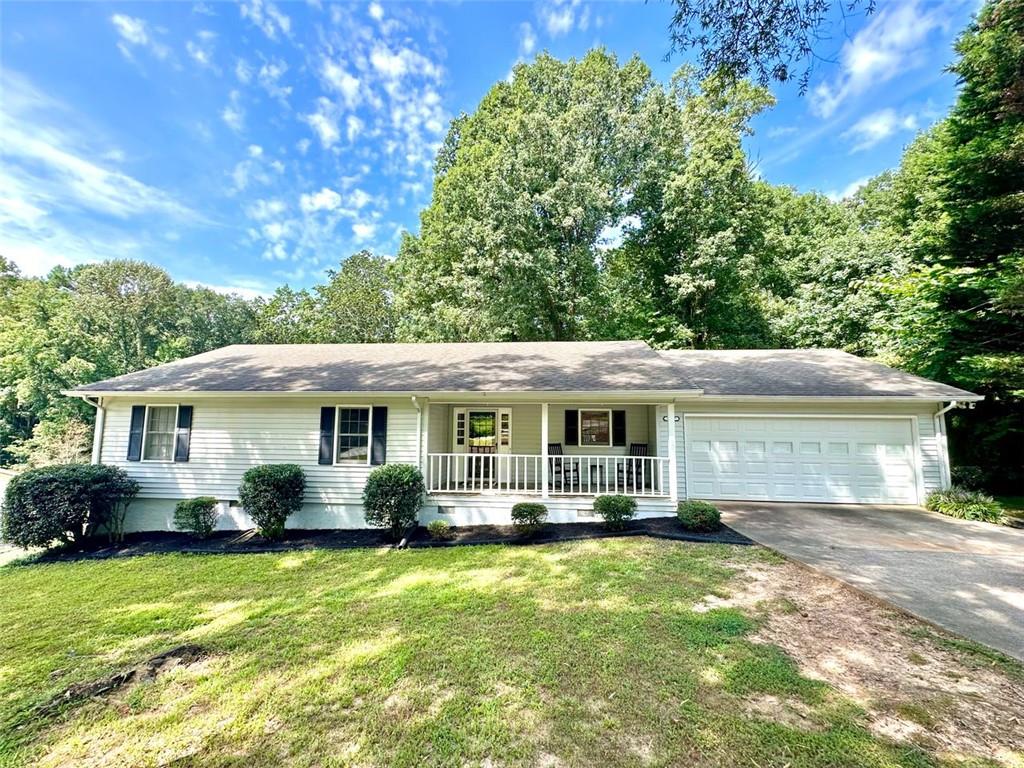 Welcome to your new home! This stunning, move-in-ready ranch offers the perfect blend of modern updates and timeless charm on a sprawling, half-acre lot in a serene, established neighborhood with NO HOA.
Step inside and be captivated by the open, light-filled living space, featuring beautiful pine wood flooring and a cozy, stone-accented fireplace that creates a warm and inviting atmosphere. The entire interior has been freshly painted, complemented by updated lighting and modern hardware throughout. Retreat to your tranquil oasis in the newly renovated master bathroom, a luxurious space designed for ultimate relaxation. The home offers three spacious bedrooms, each with generous closets, along with a large pantry & laundry room, linen closet and a bonus storage room in the garage. Relax on the rocking chair front porch or head to the backyard to enjoy the spacious deck overlooking a large, fenced-in yard—perfect for entertaining, family fun, and pets.
This home's unbeatable location is the epitome of convenience. You're just minutes from Hwy 400 at Exit 13, New Hope Elementary and the highly-anticipated Cumming City Center. Enjoy easy access to the Cumming Fair Grounds, Fowler Park, and Big Creek Greenway for outdoor recreation.
Recent updates ensure peace of mind, including a freshly serviced septic tank (2025), a new HVAC system with furnace and A/C (2021), newer water heater (2019), a new smart garage door opener (2020), and a Nest thermostat. The sale also includes all appliances, even the washer and dryer, making this a truly turn-key opportunity. Don't miss your chance to own this remarkable home in a highly sought-after location!