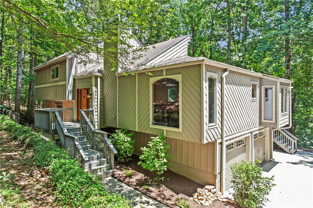 Welcome home to this beautifully renovated, private home nestled in the trees. The home is filled with natural light with large windows bringing the outdoors into each room. The main level features a large, 2-story living room with a fireplace that looks out at the back porch and an acre of tree line. There is a separate dining room with built-in shelves and upscale, renovated eat-in kitchen which includes custom quartz countertops.
Upstairs you'll find 3 bedrooms and 2 bathrooms. The owner suite walks out to its private balcony that joins the main level deck. On the lower level you'll find a bonus room perfect for an office as well as a bedroom, full bath, additional porch and the 2-car garage. All bathrooms have been recently updated. The primary bathroom includes a teak double vanity with the quartz countertops and stone flooring. Lot is very private with a beautiful view year-round and minimal noise from the road and neighbors. Located close to downtown Roswell filled with history, restaurants, shopping, and schools!
