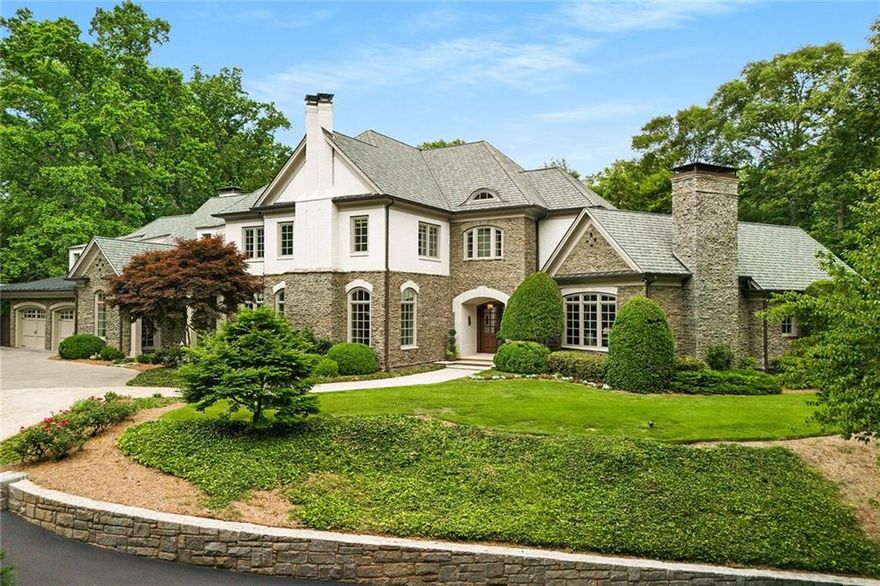 Welcome to this elegant custom-built estate in the heart of Tuxedo Park.  First time on the market, giving you an opportunity to live on one of Buckhead’s most sought-after streets.  Gated entrance and meandering driveway sit on 1.65 acres lends itself to added privacy and security. 
Step inside to be greeted by exquisite architectural details, soaring ceilings and an abundance of natural light flowing through walls of windows.  The main level boasts a stunning curved staircase, open floor plan and gleaming American Walnut floors.  Stately fireside study with wood beams and custom floor-to-ceiling shelving is perfect for cozy evenings.  The primary suite features a limestone surround fireplace and barrel-vaulted ceiling with private access to cozy fireside lanai.  The expansive bathroom has both his and her water closets and separate closets. 
Upstairs, you’ll find 4 ensuite bedrooms with ample storage.  A second laundry room is a convenient option and elevator access to all 3 floors.  The terrace level is perfect for entertaining with a stone and brick wine cellar and tasting room accented with a barreled cedar plank ceiling.  The 6th ensuite bedroom, currently used as a gym, has access to a private patio.
Set foot outside to enjoy a heated salt-water Gunite pool with an infinity edge and spa.  Bluestone patio connects two outdoor living spaces with a private restroom and pool shower. Backyard is a true oasis, offering wooded privacy within the heart of the city.  Don’t miss your opportunity to own this stunning property – schedule a showing today!