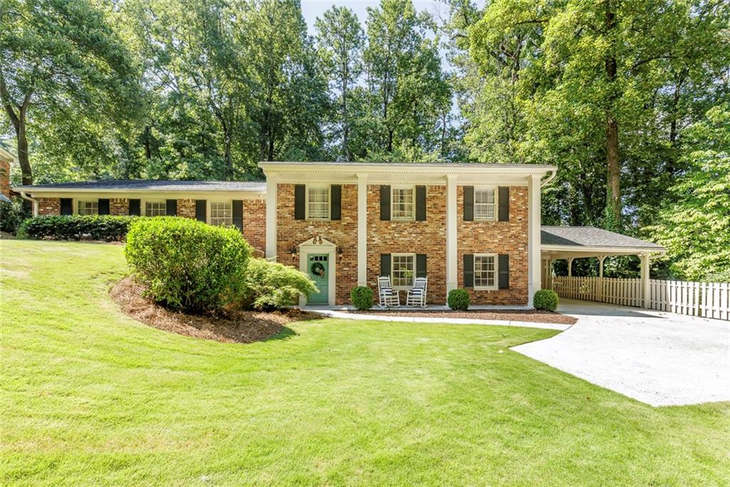 This charming 4-sided brick home in a popular neighborhood and top-rated Dunwoody Elementary is move-in ready and features a spacious, open-concept layout with a beautifully renovated and expanded kitchen that flows into a vaulted great room and dining area. Exposed beams and large windows bring in tons of natural light and offer views of the picturesque private backyard. The kitchen is truly the heart of the home-thoughtfully redesigned with an oversized island, crisp white cabinetry, built-in pantry, farmhouse sink, double ovens, and a beverage cooler, making it ideal for cooking, gathering, and entertaining! Walkout from the great room to a peaceful patio and flat landscaped backyard surrounded by trees providing total privacy - perfect for play, relaxing, or hosting guests. Upstairs you'll find three bedrooms with hardwood flooring and updated baths. The daylight basement adds even more flexible space with a large entertainment room, additional bedroom, half bath, and plenty of storage. Located on a quiet, non-cut-through street with access to the Dunwoody Trailway, this home is just minutes from parks, shopping, dining, and easy access to I-285 and GA-400. Other upgrades include a new sewer line, 50 gallon water heater, added insulation and storage shed. This is a wonderful, active community and a great find!