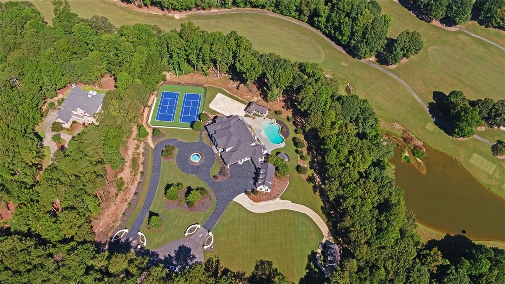 Luxury and serenity await with this extraordinary private custom estate on a 3.6 acre golf course lot with amazing views of the #5 Fairway and T-box on the private Legends Golf Course at Chateau Elan. The exquisite finishes and attention to detail in this remodel must be seen to be appreciated. Enjoy your own resort like retreat with 2 newly refinished tennis courts, a sand volleyball court, covered pagoda, saltwater heated pool, hot tub, gas firepit, playhouse and a detached garage/workshop for a total of six garages. No detail has been overlooked in this impeccable renovation with too many impressive features to mention here. With seven bedrooms plus an eighth in the carriage house, twelve fireplaces, oversized eighteen seat theater, ten person steam room, hot stone sauna, temperature and humidity controlled wine cellar, whole home audio system, three kitchens, laundry rooms and more, you will be hard pressed to find anything that compares. A study/library along with an additional spacious office are located on the main level as is the primary suite featuring a stone fireplace, an amazing spa-like bath with a spacious shower and soaking tub, laundry, dog wash and a 300 s.f. custom walk in-closet. Entering the heart of the home you will find the great room with a wall of windows overlooking the pool, golf course and pond. Custom built-ins surround the fireplace and are wired for three T.V.’s. The well appointed chef’s kitchen features an oversized Brazilian Quartzite island with plenty of storage, double ovens, microwave, two warming drawers, spice racks, cast iron sink, Thermador six burner gas cooktop, ice maker, wine cooler, walk in pantry and work station. The fireside keeping room, large eating area and sunroom offer plenty of space for family or entertaining. A guest suite with full bath and an additional laundry complete the main level. The upper level is home to four suites all with hardwood flooring, fireplaces and unique bath finishes. The back bedroom has additional space for a nursery or oversized walk-in closet. The terrace level features fourteen foot ceilings, guest suite, full kitchen / bar, eighteen seat theater, family / billiard room with double sided fireplace, exercise room, game room, sauna, steam room, pool bath, laundry room, craft room and a wine cellar! The guest suite over the separate three car garage has a private entrance, full kitchen, sitting area, bedroom and walk-in closet. As beautiful as the interior is, you will be even more amazed with the completely private, resort style backyard. So many options for entertaining or enjoying your own private paradise. Full Legends Golf Membership INCLUDED.