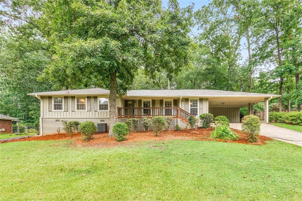 Welcome to 1556 Smithwood Drive, a charming 3 bed / 2.5 bath ranch home tucked away on a quiet street in East Cobb. This well-maintained property welcomes you with hardwood flooring throughout and a formal sitting room just off the foyer. The fireside living room creates a warm and inviting atmosphere ideal for everyday living or entertaining. Cooking is a delight in the updated kitchen featuring white cabinetry, stainless steel appliances, and a bright, open layout with plenty of natural light. The primary suite serves as a peaceful retreat, complete with a private en suite bath featuring a jetted tub and separate shower. Two additional bedrooms and a full bath provide comfortable accommodations, all conveniently located on one level. Step outside to a peaceful, wooded backyard where the patio area offers a quiet spot for morning coffee, outdoor dining, or simply enjoying the fresh air. A detached garage offers added convenience and storage space. Located in a great neighborhood within the Sprayberry High School district, with easy access to shopping, dining, and more.