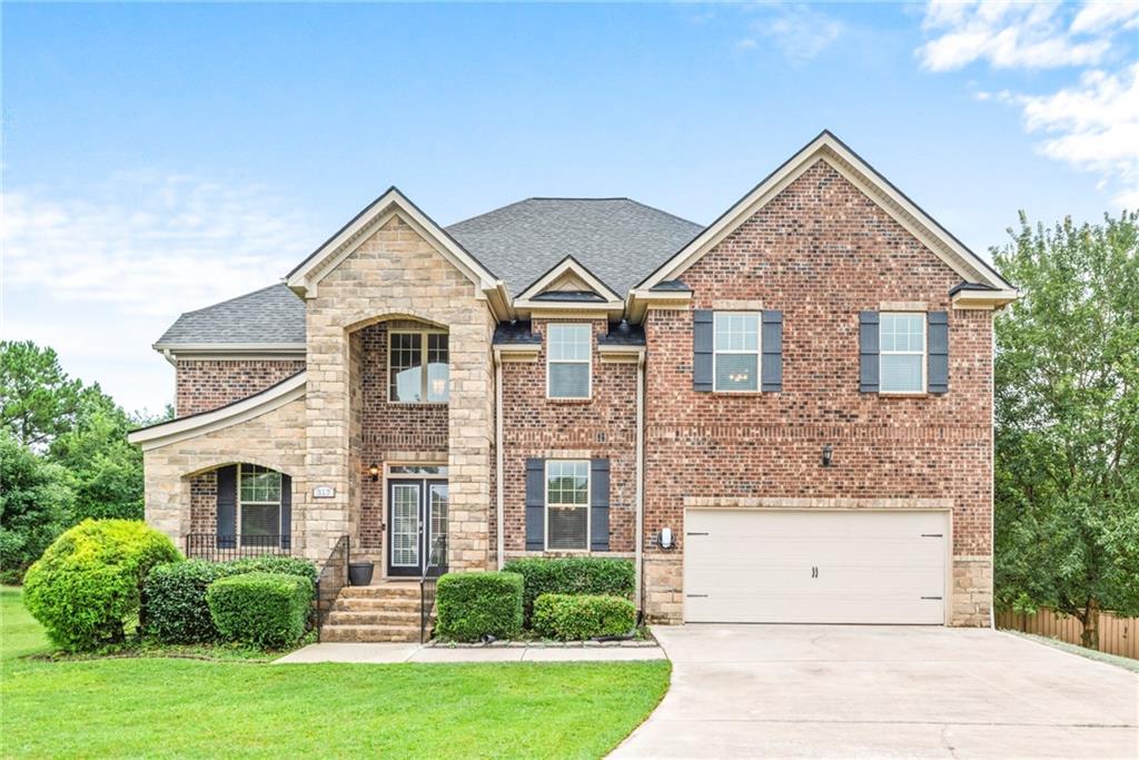 Welcome to 317 Hitt Trace—a stunning full-brick home offering 6,341 square feet of beautifully designed living space, perfectly positioned at the entrance of a peaceful cul-de-sac in the sought-after East Lake Estates community. Within walking distance to the top-rated Union Grove School District, this 5-bedroom, 4-bathroom residence blends spacious living, thoughtful upgrades, and timeless style.
Inside, a well-designed layout offers a main-level bedroom with an adjoining full bath—ideal for guests or multi-generational living. The chef’s kitchen is a true centerpiece, boasting double ovens, ample counter space, a built-in desk for paying bills or organizing the home, and an open view into the cozy family room. Here, a dramatic stacked-stone fireplace is framed by an elegant coffered ceiling, while rear stairs provide private access to the owner’s suite.
Just off the garage, a practical mudroom with a built-in bench keeps life organized and clutter-free. Entertain in style in the formal dining room, complemented by a convenient butler’s pantry. Upstairs, the oversized owner’s suite serves as a private retreat with a generous sitting area anchored by a second fireplace, and the entire second level is refreshed with brand-new carpet for a clean, move-in-ready feel.
The fully finished daylight basement—completed in 2020 with Henry County permits—was designed for both functionality and fun. Highlights include ceiling speakers for an immersive entertainment experience, a stacked-stone bar, a closet for a stackable washer and dryer, a private gym enclosed with sleek solid-glass doors, a bedroom with an adjoining full bath, a dedicated home office, and a living area off the bar that’s already pre-wired for a home theater.
Outdoors, enjoy a fully fenced backyard perfect for pets, play, and quiet evenings. A spacious 2-car garage, manicured landscaping, and exceptional curb appeal complete this remarkable property.
Don’t miss your opportunity to own in one of Henry County’s most desirable communities!