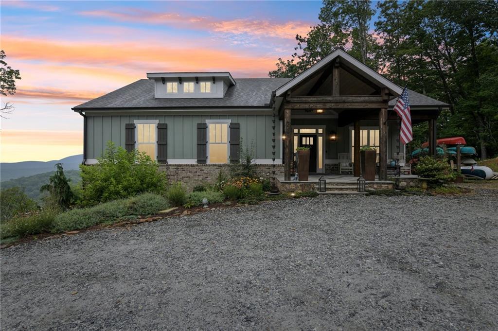 Take in the BREATHTAKING VIEWS of the Blue Ridge Mountains from your PRIVATE mountain retreat in Dahlonega. Situated at the end of a private street not accessible to through traffic, this home offers privacy & seclusion all wrapped up in gorgeous modern finishes. The sweet stone front porch welcomes you into the home where the moment you walk in your eyes will drift off to the picture windows beckoning in the stunning mountains beyond. The open concept living plan is accentuated by the best of the best in decor and materials, from board and batten, to custom wallpaper, tile work, stone and wood, texture and design can be found throughout the home. The kitchen offers a mix of open shelving, custom cabinets, a spacious custom pantry and a large island for casual meals. Complete with top of the line appliances including a 6 burner gas range & wine cooler this kitchen has everything a chef would desire. The MASSIVE Butler's pantry/mudroom/laundry room includes a sink, pet faucet for your furry friends and loads of additional cabinetry. The Primary bedroom even has access to the laundry room making this task a little more enjoyable. The Primary on Main is just what it should be, a relaxing retreat from the everyday complete with an en suite bath with its double glass shower, custom closet and don't forget the incredible views accessible from your private French doors leading out to the covered deck. Owner's will enjoy the dedicated office space with views of the beautiful landscape making this an enjoyable place to work. Another additional bedroom on the main living floor and a secondary bath complete the main living floor. Downstairs two more very spacious bedrooms and another full bedroom allow room for everyone and everything. The additional family room on the lower level also provides a great place to unwind, watch a movie or play games with family and friends. But you will spend hours relaxing and enjoying the outdoors on your covered back deck overlooking the mountains and enjoying unparalleled views. This home has SO much to appreciate, from design to views, this is a once in a lifetime opportunity. Make this your private residence or turn it into a profitable STR, the possibities are endless.