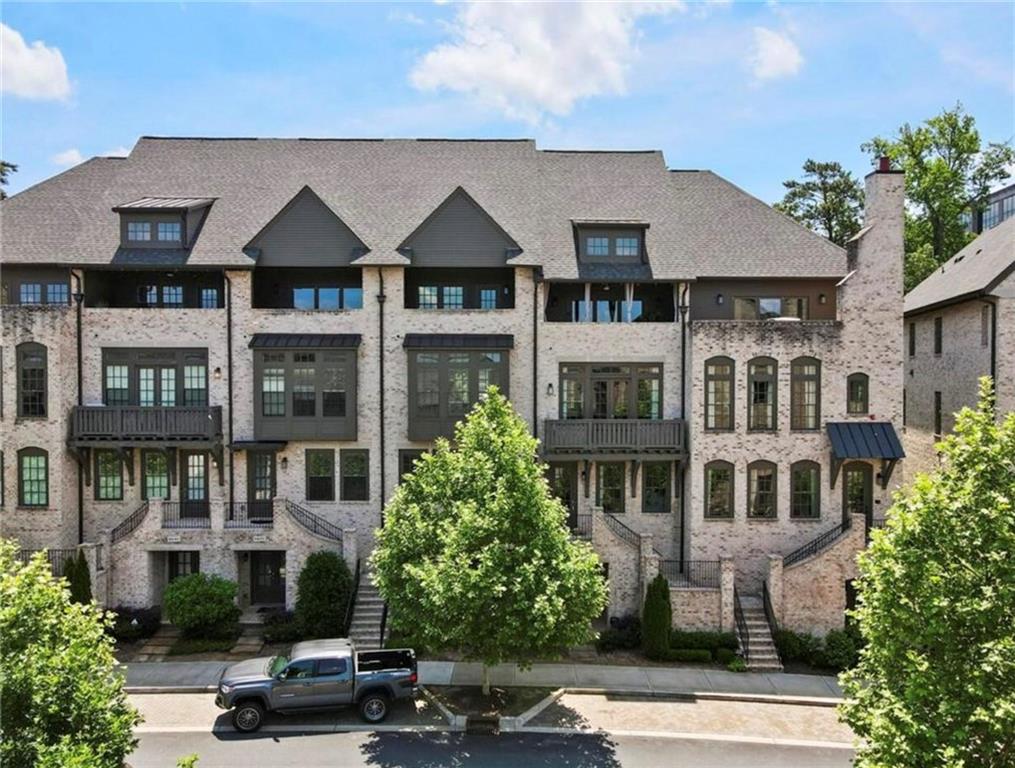 Welcome to Aria, a first-class neighborhood in the heart of Sandy Springs. The community offers resort like amenities including two community pools, pool house, club house with pool table, game room, fitness center, meeting room, board room, walking trails and a 12-acre park. Just across the street discover retail shops and restaurants like La Parilla and Food Terminal. Conveniently located near several breweries, Abernathy Greenway, Perimeter Square, Target, Trader Joe's, Mercedes-Benz USA, and more. There is easy access to GA-400 and 285.

Inside the home you will find a chef's kitchen features 13' long island with bar seating, quartz countertops and stainless-steel appliances. Kitchen opens to large dining room area. In the family room, also open to kitchen, you’ll find a modern brick fireplace surround stretching to the 10' high ceiling. A roomy balcony is just off family room overlooking a private tree lined back yard. NO backing up to a neighbor! Your primary bedroom is oversized and has a walk-in closet outfitted with custom cabinetry. An additional guest suite is also located on the top floor. Here on the top floor, you’ll  find a covered rooftop patio with stunning views. On lower level you will find a daylight finished basement with full bath. The private entrance makes the basement ideal for a teen suite or office. Deck and garage face a private wooded area. ELEVATOR-READY shaft/closets on each level provides ample storage. Two-car garage. There is plenty of guest parking on Cadence Blvd.