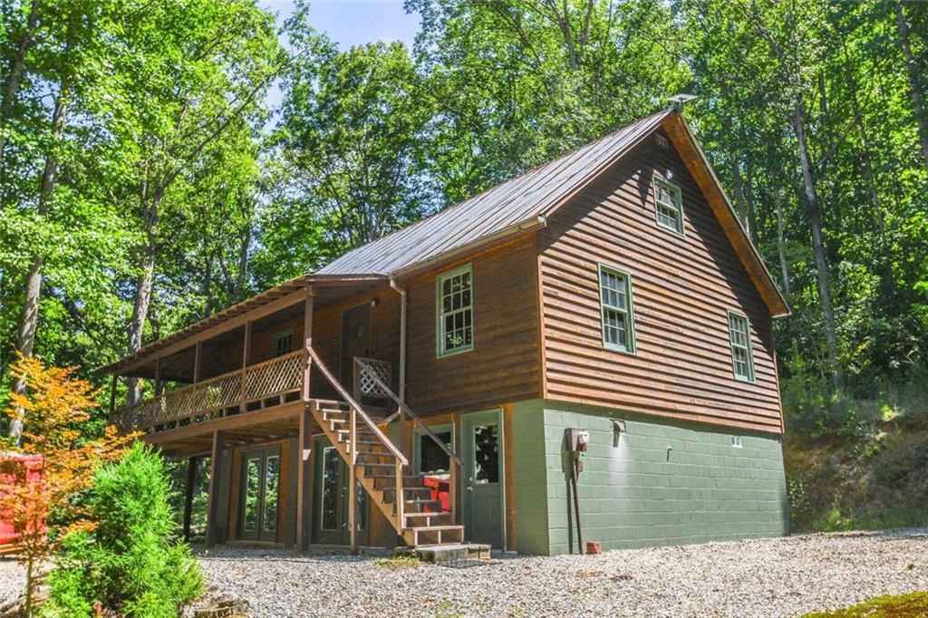 BEAUTIFUL 2 bed/1.5 bath cabin w/loft on FULL BASEMENT! This serene piece of property sits on a peaceful 6.5 acres! MASSIVE basement is full of wood working equipment - it makes an excellent workshop, man cave, storage room, you name it! The basement can easily be converted into additional living space if your heart desires! Wrap around rocking chair porch has amazing views of the woods and lands below! Loft has sleeping area as well as a 1/2 bath! Come see this property before its too late! Priced to move fast!
