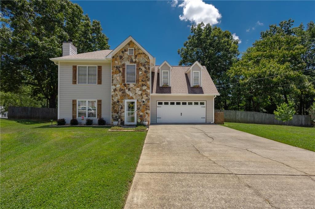 Well-maintained beautiful 4 bedroom, 2.5 bathroom home is minutes to downtown Sugar Hill! The lovely kitchen features white cabinetry, granite countertops, tile backsplash, separate island, stainless appliance package, and eat-in breakfast area with bay window and amazing view of the backyard. Separate formal dining room. Spacious family room presents a stone surround fireplace with raised hearth, white mantle, and ceiling fan. Updated half bath on main level. Upstairs you will find the oversized owner's suite with complete remodeled bathroom - huge tile shower with bench, 2 inserts, sliding glass doors, and double vanity. Oversized secondary bedrooms all with ceiling fans. Enormous backyard with privacy fence, large patio area, swing that is perfect for enjoying your morning coffee of evening glass of wine, playground area, planter space, and separate storage building. Additional features: high end laminate flooring, water heater, garage door - all just 2 years young, all toilets replaced to low flow, and plumbing on main level to PVC. This is your new place to call home!