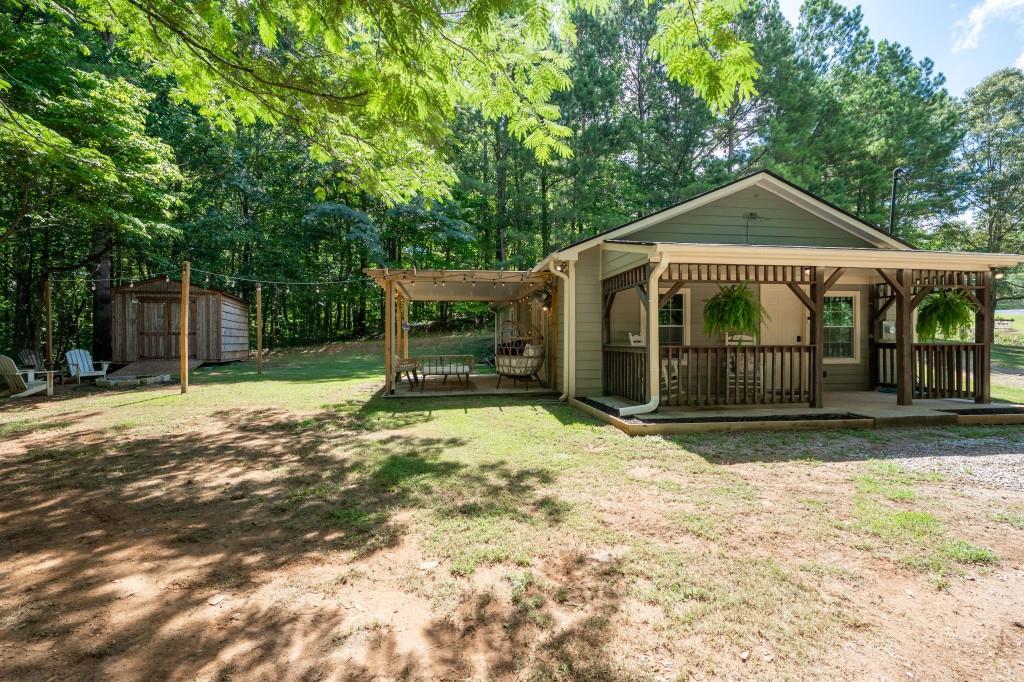 This house is ADORABLE! So many new upgrades, about 40K worth of new additions. Rocking chair front porch invites you into this home. Kitchen completely remodeled including Newly installed island with cedar columns, farmhouse sink, new appliances including dishwasher, oven and microwave, Butcherblock counter tops, new cabinets and pulls with drawer under the stove and lazy susan cabinets. Electric ran to the island as well. Shiplap added in the kitchen along with floating shelves. New light fixtures in Many places including the kitchen. Added ceiling fans in den and extra bedrooms. Many rooms freshly painted. New barn doors added to washer and dryer area and pantry. LVP flooring throughout the house. New Septic and all new field lines. And outside has been created to be an oasis too! New Pergola with under decking so you can enjoy being outside rain or shine! Firepit added with cafe lights surrounding it. Plus, an awesome $10,000 shed size 10x18 with shingle roof was added for storage and workshop area. This house has great outdoor space plus plenty of room for parking. Such an adorable home, it's a must see for sure!