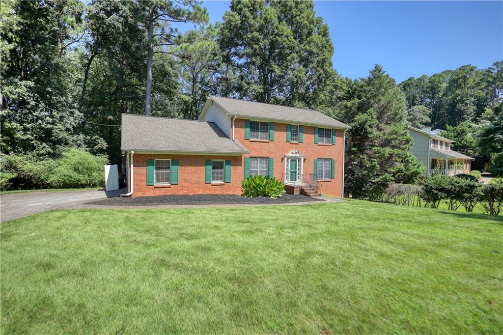 Welcome home to this charming, brick-front two-story on a basement that offers a private, wooded backyard, side entry garage, and deck. Basement level has 2 rooms finished and a large storage/workshop area. On the main floor, enjoy formal dining, a formal living room and a family room with a brick-hearth fireplace. All bedrooms are upstairs including a spacious primary suite. You'll love having space between your neighbors and the convenience to major roads like 78, 285, Atlanta, restaurants and shopping. Venture to the Yellow River at the back of the property for scenic views and calming experiences. A FEW PERSONAL TOUCHES AND THIS WILL BE YOUR DREAM HOME!