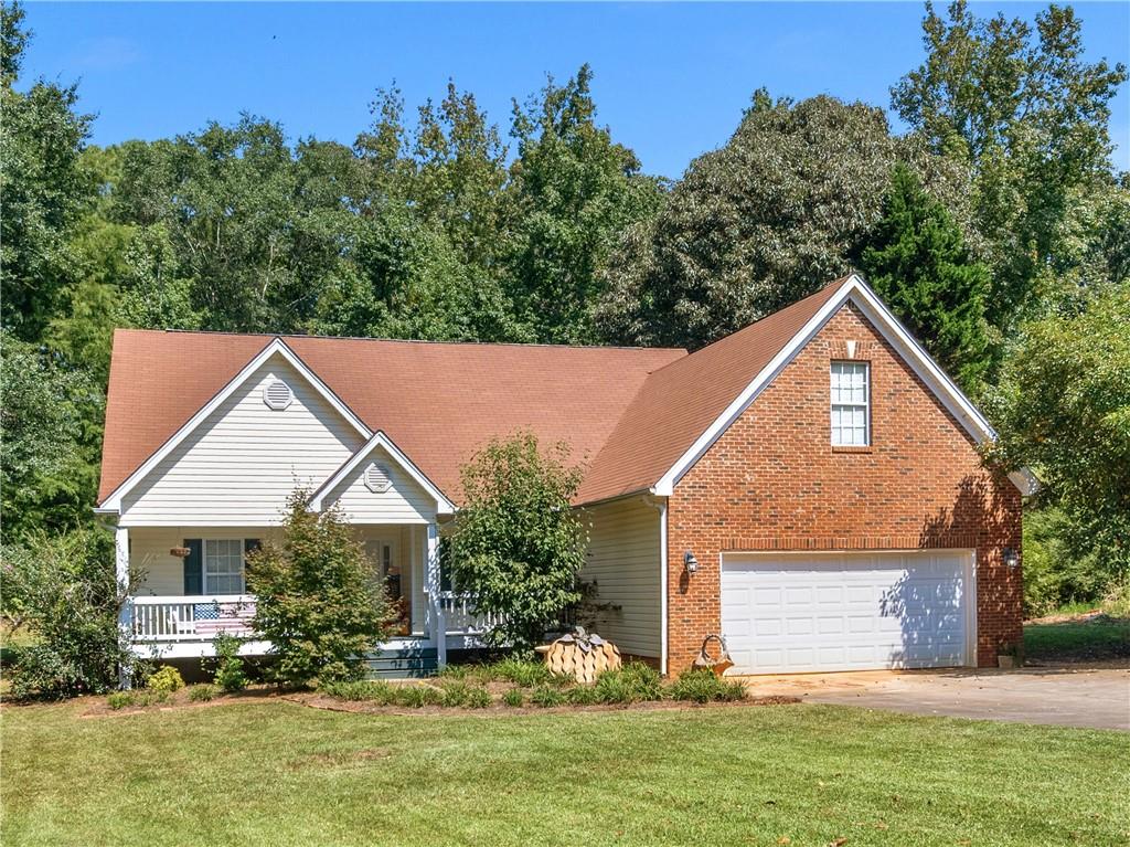 Welcome to this charming home located just minutes from Jackson Lake in a wonderful, established community. This 3-bedroom split plan offers all bedrooms on the main level with a versatile bonus/flex room upstairs, (not pictured)perfect for a home office or hobby space. Formal dining room with a beautiful tray ceiling, a two-story great room with a cozy fireplace, and an updated eat-in kitchen featuring striking black and glass cabinets, upgraded pull-out drawers, and elegant quartz countertops. The spacious primary suite includes a walk-in closet, garden tub, and separate shower, while two additional bedrooms on the main share a full bath. Enjoy relaxing on the covered back porch as you take in the peaceful natural setting or sip your morning coffee on the welcoming rocking chair front porch. This total electric home has hardwood floors in the main living areas, carpet in the bedrooms, and plantation shutters that remain with the home. Additional features include a two-car garage, a 12 x 20 storage shed, and a private fenced one-acre lot. The roof is less than 10 years old, the fireplace was cleaned within the past two years, and the water heater is approximately four years old. Move-in ready and ideal for a first-time buyer, this home offers the perfect blend of comfort, style, and convenience.