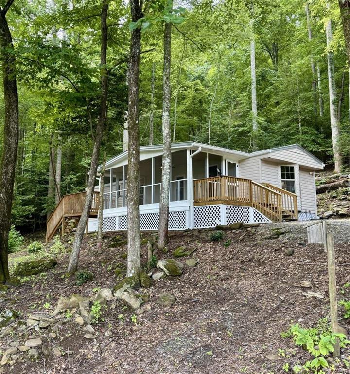 Updated 3BR/2BA home in a great Hiawassee location with seasonal long-range mountain views. Nearly everything is new—flooring, light/plumbing fixtures, vanities, cabinets, countertops, windows, paint, roof, and a 1-year-old water heater. Enjoy mountain air from a huge screened front porch, plus two additional porches for entertaining. Perched at the crest of a hill, this move-in ready home offers charm, comfort, and affordable mountain living.