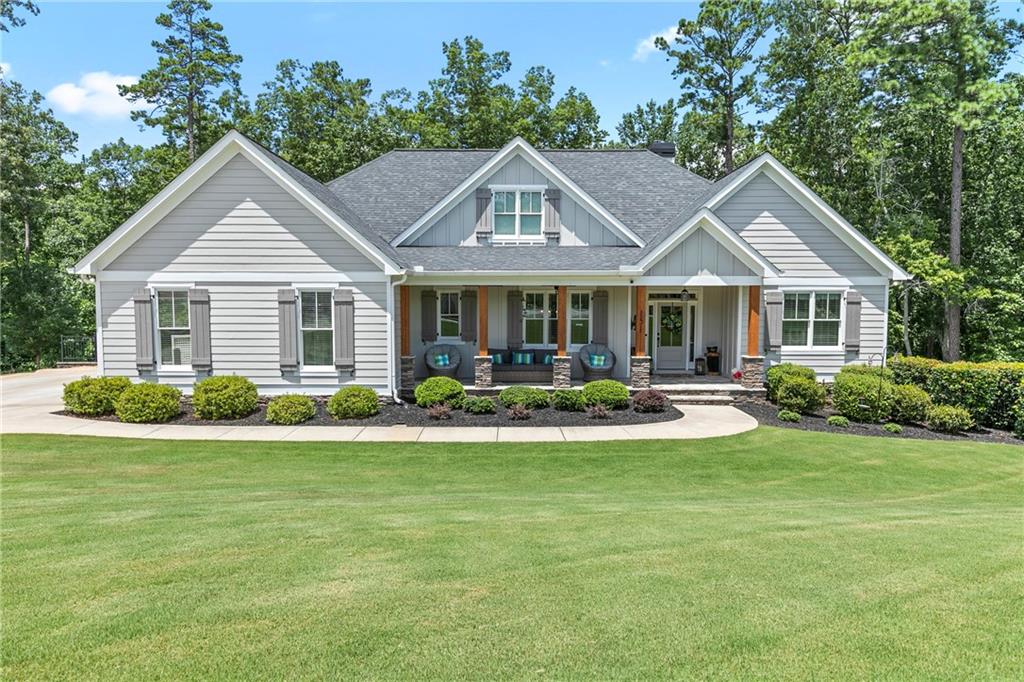 Take a look at this stunning, custom-built ranch home tucked away on a private cul-de-sac in beautiful Cherokee County! Situated on over an acre of meticulously maintained land, this home offers a peaceful setting with a level driveway and an oversized garage that can even accommodate a boat. Step inside to an open concept layout filled with natural light, featuring cathedral ceilings with cedar beam accents in the spacious family room, fresh interior and exterior paint and gleaming hardwood floors throughout. The chef’s kitchen is the heart of the home with a large island, gas cooktop, ample cabinetry, walk-in pantry, and stainless-steel appliances. The oversized owner’s suite on the main level includes two custom walk-in closets, and a spa-like bath with dual vanities, granite countertops, and a large centered soaking tub. Enjoy cozy evenings on the screened-in porch with tongue-and-groove ceilings and an outdoor stone fireplace—perfect for relaxing or entertaining year-round. Downstairs, the terrace level has been transformed into the ultimate entertainment zone, complete with a large rec room, full bar, game TV area, home gym, full bath, and a private bedroom with a full bathroom. You'll also find a workshop, safe room, tons of storage, and a huge unfinished space ready for your personal touch. Step outside to the covered terrace-level deck with a hot tub and admire the peaceful wooded backyard and stone firepit gathering area. A great place to entertain friends and family. This hidden gem offers unbeatable access to I-575 and I-75 for an easy commute and is just minutes from Lake Allatoona, Lake Arrowhead, Fields Landing Park, Knox Bridge Landing Boat Ramp, Sweetwater Campground, and Little River Marina not too far away. Conveniently nestled between Canton and Cartersville, you’ll enjoy all the perks of Cherokee County living without the hassle of traffic or congestion. This home truly has it all.