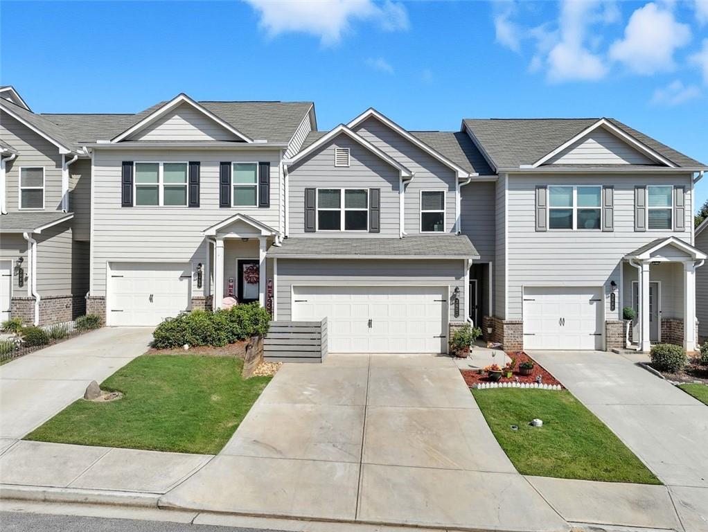 Nearly new Townhome in Oakwood not far from Lake Lanier. Walking distance to Oakwood Elementary School. Private rear yard. 2 Car garage! All bedrooms and laundry room on upper level. Kitchen with large center granite island featuring white cabinets opens to large family room with electric fireplace equipped with logs. Walk in pantry in kitchen, electric range, microwave and dishwasher. Plenty of countertop space for your chef tools! Natural light flows beautifully into main level through double windows. Powder room located in hallway to garage. Private rear patio is perfect for entertaining and grilling. Upper level is complete with spacious Owners Suite featuring a pretty trey ceiling and two closets. Owners bath has large soaking tub, double sinks, shower and leads to laundry room.... how convenient! Secondary bedrooms are generously sized and served by 2nd bath. Pride of ownership is evident in details and condition of the home.