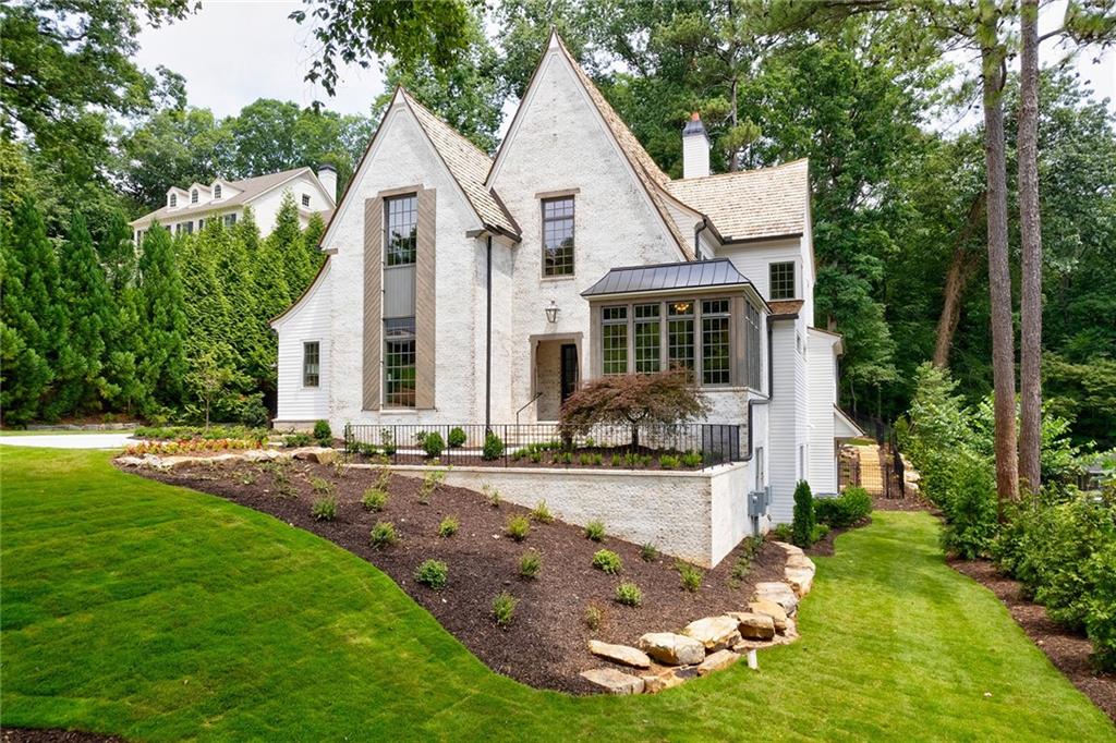 Absolutely stunning new construction built by 2022 Atlanta Builder of the Year, Vincent Longo Custom Builders. Sought after location on a private cul-de-sac lot, close proximity to Chastain Park and Holy Innocence. The attention to detail makes everyday living feel luxurious! This 5 bed, 4.5 bath home boasts an open-concept floor plan, hardwood floors, and opulent designer selections. The main floor offers a gracious floor plan, perfect for entertaining with a large family room and dining room flanked with 16 foot steel doors that open to a large covered porch complete with outdoor living, 36" built in gas grill, beverage center, and double sided linear fireplace with views from both the porch and a sparkling pool and spa. Backyard is an oasis of natural beauty with complete privacy including lush landscaping with artificial turf, oversized boulder wall, and serene elevated space perfect for a firepit or sitting area. The first floor Master Suite overlooks the patio and backyard, and features a spacious custom closet with washer and dryer, and a dream one of a kind design free-standing tub and top of the line Kohler Anthem digital shower system with Wi-Fi that allows the homeowner to customize their shower for the perfect spa-like experience. Impressive home office space accented with two walls of large floor to ceiling windows give abundance of natural light and overlooks the front yard. Open chefs kitchen with custom lacquered cabinetry & premier Thermador appliances, upstairs game room, plus bonus/craft room, upper level laundry complete with wallpaper and custom cabinetry. Exterior is a warm white lime washed brick exterior accented with gas lanterns, cedar corbels and cedar shake roof. 3 car garage. Walkout terrace level is ready to finish to your preference with ample flex space for home gym, media room etc, additional bedroom/bath. All mechanicals are in place including insulation and full installed HVAC system. Designer decor and custom detail finishes throughout. This home has a wealth of amenities to offer! Some photos in this listing have been virtually staged