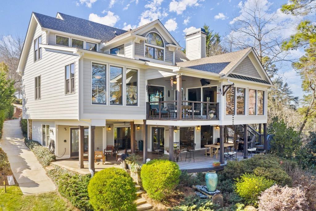 Welcome to a Rare Opportunity for Exceptional Lakefront Living on the South End of Lake Lanier with the ability to be sold turn-key furnished. This stunning craftsman lakefront estate, is behind secure gates on one of Lake Lanier's most coveted private point lots. Positioned on the sought-after south end of Lake Lanier, this exceptional property provides the perfect blend of tranquility and accessibility. Mere minutes from marinas, charming lakeside restaurants, and the convenience of the city of Buford, known for its boutique shopping and modern amenities. Independence Day becomes an unforgettable celebration as you watch the July 4th fireworks over Lake Lanier Islands, all from the comfort of your own private dock. This point lot's gentle slope offers rare, easy access to the lake. At the heart of your waterfront lifestyle is a (four-year-new), deep water Wahoo dock, 32' x 32', complete with a party deck for sun-soaked afternoons and starlit gatherings. A boat slip and slip for two jet ski hoists are ready for spontaneous fun, while enjoying the unobstructed 250-degree view across the deep-water channel. A craftsman home with three luxurious levels, this extraordinary residence has been designed for both grand entertaining and intimate family living. The three finished levels offer nearly endless flexibility and space. The main level sets the stage with an open concept plan that seamlessly connects the luxury kitchen, dining area, and great room. A chef's kitchen, well-appointed with top-tier stainless appliances, including a Wolf gas range and Subzero refrigerator. An expansive central island opens to the adjacent dining area and great room, where soaring two-story vaulted tongue-and-groove ceilings and a masonry stone fireplace. Walls of windows flood the space with natural light and frame breathtaking views of the water, ensuring that lake vistas are always a part of your daily experience. Retreat to the primary suite, designed for relaxation and rejuvenation. The accompanying spa-inspired bathroom features a steam shower. For those who work from home or crave a quiet space for reflection, the home office-complete with inspiring lake view. The sunroom and expansive covered porches invite you to begin each day with panoramic sunrise views, a steaming mug of coffee, and the peace that only lake living can provide. Upstairs, three generously sized bedrooms ensure that guests and family enjoy privacy, comfort and lake views. Among these is a second primary suite. The fully finished terrace level transforms the home from extraordinary to exceptional. Here, a second kitchen opens opportunities for multi-generational living or effortless entertaining. Gather with friends in the spacious living area, or indulge your passion for fine wines in the dedicated wine cellar. The terrace level opens directly onto a sprawling covered patio, where you can savor cool lake breezes and the gentle sounds of nature. A workshop provides space for hobbies or projects, while an additional outdoor shed is ready to store all your boating and lake toys. Each floor is equipped with its own laundry. The absence of an HOA ensures freedom and flexibility, while the home's Buford address brings the benefit of low Hall County taxes-a remarkable value for such a prestigious location. Recent updates include five newer HVAC units and plush new carpeting in all bedrooms as of 2022. The property also features extensive storage solutions, with a terrace level workshop and outdoor shed designed for all your equipment and lake essentials.