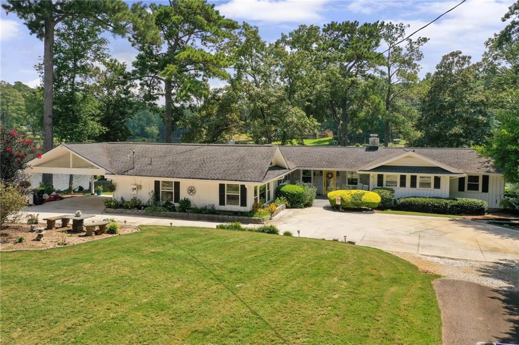 Discover peace, quiet, and natural beauty in this updated, well-maintained ranch style home located on Lake Jodeco. Perfect for nature lovers, boating and fishing enthusiasts, this property features its own covered boat dock, and approx 226 feet of water frontage making it easy to enjoy the water just steps from your door. Lake Jodeco is perfect for leisure, kayaking, fishing and quiet boating with a no wake zone. Inside, you'll find thoughtful updates and comfortable living spaces designed for year-round enjoyment. This well maintained home offers a total of 4 possible bedrooms and bathrooms with one being handicap-accessible Two of those bedrooms feature cozy fireplaces, creating warm retreats during cooler months. The 4th possible bedroom is currently being used as a large den/rec room. In addition, you'll find a living room/dining room combo with a wood burning insert in the fireplace, sunroom with stone floors, fantastic kitchen with great cabinet space, bonus room perfect for a home office, reading or whatever you need while still enjoying the lake view. The majority of this fantastic home has hardwood floors and no carpet. The views of the lake are absolutley stunning from multiple rooms in this home. The owner has spent so much time and money on this property to make sure that every little detail has been addressed from waterproofing the crawl space, replacing the windows and doors, replacing the hvac, deck, roof, gutters and adding gutter guards, adding a sprinkler system fed from the lake, extensive landscaping, adding a firepit and so much more. Surrounded by serene views and abundant wildlife, this home offers the perfect balance of comfort and outdoor living-whether you're watching the sunset over the lake, or simply enjoying the quiet atmosphere. Don't miss your chance to own this inviting lakeside retreat where relaxation and recreation come together in this nature lover's paradise. A slice of heaven just 20 minutes from the Atlanta airport.