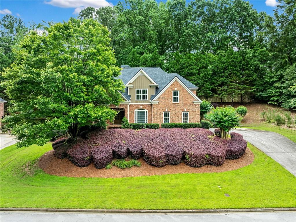 Welcome to this timeless and elegant 3 sides brick estate where classic charm meets refined living. Nestled on a beautifully manicured lot in a sought after location, this 4 bedroom 3.5 bath masterpiece offers the perfect blend of comfort, sophistication, and convenience. A grand front entrance with double French doors sets the tone, leading into a warm and inviting foyer adorned with designer lighting and gleaming hardwood floors that flow seamlessly throughout the main living areas. Entertain in style in the formal dining room or gather in the breathtaking 2 story great room featuring custom built ins, a cozy fireplace, and a dramatic wall of windows that bathe the space in natural light. Floors refinished in 2022. The gourmet kitchen is a chef’s dream complete with richly stained cabinetry, granite countertops, a large island, gas cooktop, new double ovens, new refrigerator and an airy breakfast nook perfect for morning coffee. Retreat to the oversized owners suite on the main level, a true sanctuary with a deep tray ceiling and an elegant sitting room with a fireplace and coffered ceiling ideal for a private office, reading room, or peaceful escape. The spa inspired owners bath offers double vanities, a soaking tub, separate tiled shower, and exquisite finishes throughout. Upstairs you will find a spacious loft and generously sized secondary bedrooms perfect for family or guests. The full basement offers endless potential and includes a partially finished area ready for your personal touch—ideal for a home theater, gym, or recreation room. The flagstone patio features a charming gazebo and creates the ultimate space for outdoor living and entertaining. A new roof adds even more value and peace of mind. Located in a prime area with easy access to shopping, dining, parks, and major attractions and just steps away from the Collins Hill Aquatic Center, this home is truly a rare find that blends luxury, function, and beauty in every detail.