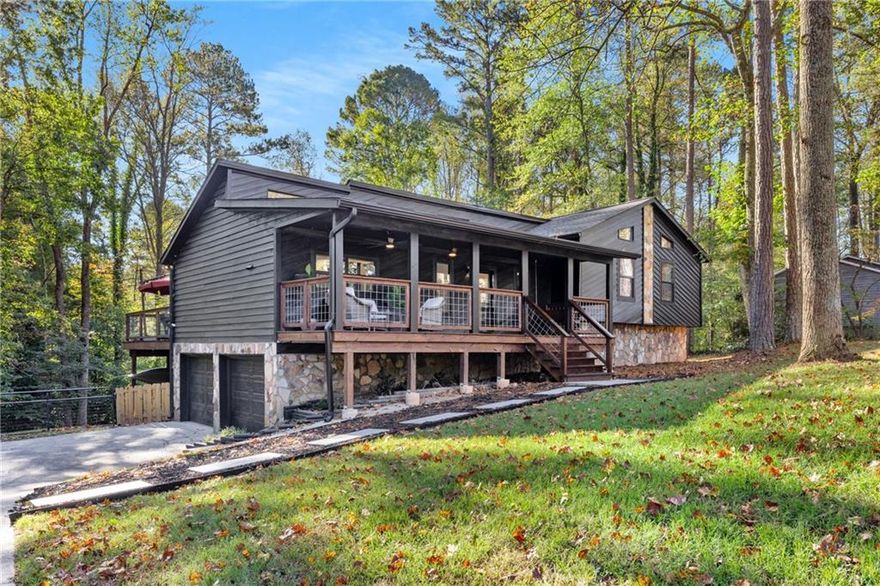 A private mountain-style retreat right in the heart of Woodstock. Tucked away on a quiet street, feels like an escape to the mountains, yet it sits right in Woodstock close to shops, restaurants, and top-rated schools. This is the kind of home that makes you breathe easier the moment you arrive. Surrounded by trees and peaceful views, it feels like a weekend getaway that never ends. Inside is a completely renovated home that blends rustic charm with modern luxury. Every inch has been reimagined, starting with a brand-new roof, new paint, and new windows. High vaulted ceilings fill the home with natural light, and new flooring ties everything together with warmth and style. The kitchen is the centerpiece of the home. Stainless steel appliances, sleek recessed lighting, and an accordion-style sliding glass door create a space that feels open and inviting. That door leads to a massive custom-built deck that stretches across the entire back of the home. Nearly seventy thousand dollars were invested into this outdoor space, which connects directly to the primary suite and offers the perfect setting for quiet mornings or evening gatherings under the stars.  The primary suite feels like your own lodge-inspired retreat. It has vaulted ceilings and a spa-style stepless shower with luxury tile, double shower heads, and a new vanity. The two secondary bedrooms include a fun connecting door between their closets, perfect for kids who love secret hideouts. The hallway bathroom is completely renovated with fluted wood-look tile, stylish fixtures, and a skylight that fills the space with natural light. The finished basement is designed for relaxation and entertainment. It features a large open area perfect for a movie room, a fourth bedroom, and a storage room that could easily be converted into a future bathroom. The two-car garage has been insulated, heated, and air-conditioned for year-round comfort. It includes brand-new garage doors,  a built-in doggie door that opens to the fenced backyard, making life easy for your four-legged friend. Outdoors, the updates continue with a rebuilt front porch with a cozy swing that invites you to slow down, relax, and enjoy the peaceful surroundings, an above-ground pool surrounded by decking, and a storage shed. The property sits on more than half an acre with a beautifully maintained lawn and no HOA, giving you the freedom to enjoy it your way. Every detail in this home was thoughtfully designed, from the lighting to the finishes. It feels like a peaceful mountain getaway, yet it is fully modern, move-in ready, and located right here in Woodstock.