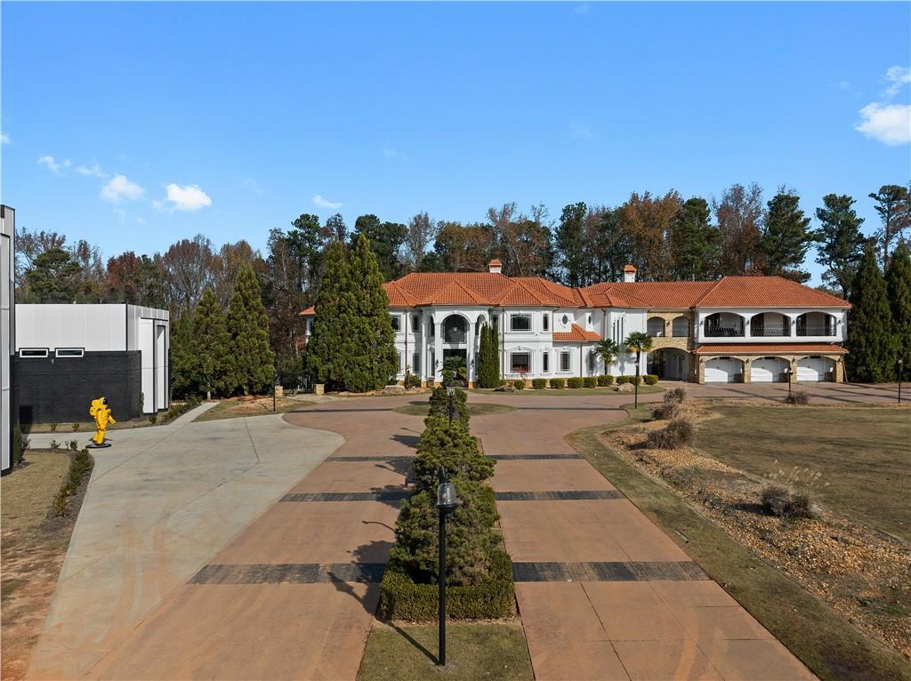 Welcome to 5096 Stephens Road, Gainesville, GA, a rare and extraordinary estate spanning 6.36 acres in one of North Georgia’s most sought-after locations. This property offers not just one, but TWO distinct luxury residences—a stunning European-inspired main home and an expansive 9,300 sq. ft. recreational complex, creating a one-of-a-kind living experience that blends sophisticated elegance with resort-style amenities.
The main residence is a masterpiece of craftsmanship, featuring exquisite details like ornate wood trim and handcrafted steel railings. Designed for both grandeur and comfort, this home offers multiple sitting and living areas that provide versatility for hosting, entertaining, or simply enjoying everyday luxury. The gourmet chef’s kitchen is outfitted with top-tier appliances, granite countertops, and custom cabinetry, setting the stage for culinary excellence.
Beyond the main home lies an exceptional recreational complex, unlike anything on the market. This 9,300 sq. ft. entertainment space boasts a two-lane bowling alley, an indoor basketball court, an indoor swimming pool, and multiple recreation rooms, making it the ultimate retreat for both intimate gatherings and large-scale entertaining. Whether you want to host an executive meeting , entertain, or workout, this space has unlimited possibilities,
Step outside into your own private oasis, where an in-ground lagoon-style pool, spa, and lazy river offer a resort-style experience in the comfort of your backyard. The expansive patio, outdoor basketball court, and meticulously landscaped grounds enhance the exclusivity of this estate, creating a sanctuary designed for both relaxation and recreation.
This remarkable property presents an unmatched value, priced at more than $500,000 below its recent appraisal, offering an incredible opportunity for the next owner to come in and infuse their own personal touches. With two fully equipped residences, this estate provides the rare opportunity to own two luxury properties for the price of one.
Located just moments from Lake Lanier and Gainesville’s premier luxury developments, this home is a true masterpiece in one of Georgia’s most desirable areas. From its architectural grandeur to its world-class amenities, this estate is a rare offering that will exceed even the highest expectations.