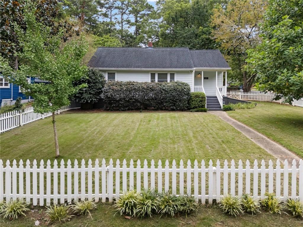 Adorable and cozy, renovated bungalow less than a mile from East Atlanta Village. Incredible neighborhood location situated on a large corner lot with white picket fence, Zoysia sod, and a covered front porch. The open floor plan features refinished hardwood floors and updated fixtures. The kitchen offers white shaker cabinets, granite counters, subway tile backsplash, and newer appliances, including a gas range. The large primary suite includes a walk-in closet and private bath with a large tiled shower. A third bedroom can serve as an office, gym, or dining room. Several outdoor spaces include a back deck, brick patio, and fenced backyard. Newer HVAC and roof, double-pane windows, and waterproofed basement with lots of dry storage. Convenient to parks, shops, dining, and major highways. If you like to walk to get coffee and bagels in the morning, this is the best of intown living: wonderful neighbors in a super walkable community.