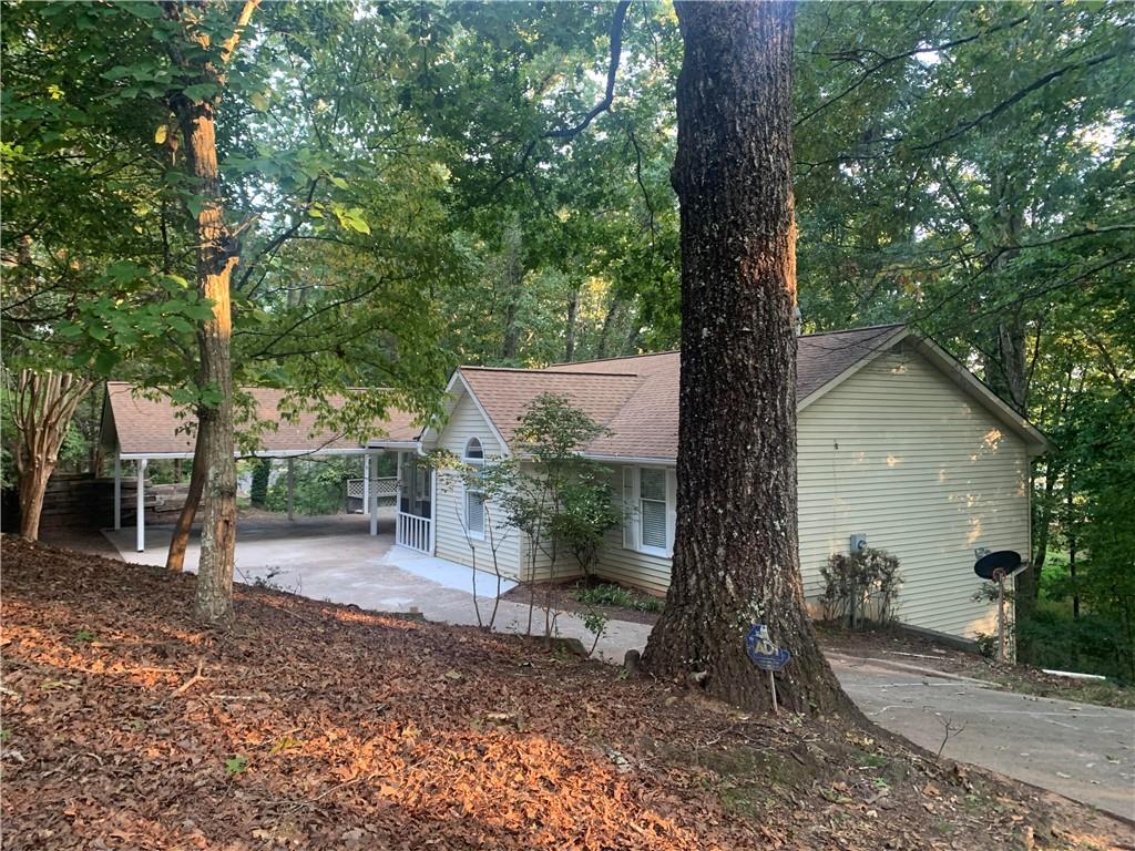This 3 bedroom 2 bath home is bigger than it looks! Large cathedral living room with decoration only fireplace. Kitchen is light with plenty of windows and oak cabinets. There is a four season sunroom or sleeping porch. Master on main with double closets and a Jacuzzi tub and separate shower. House has several pocket doors for privacy. Laundry is on the main level. Downstairs has a split bedroom plan with two bedrooms at opposite ends and a Family room in between. LVP flooring….Extra, extra large bathroom. Downstairs has a finished storage area or make a great office. Workshop and utility room is downstairs too.
Extra wide doors on main level. Multiple decks and sitting areas to enjoy the outside. Double carport plus plenty of parking. Very little yard to mow. All natural woods with seasonal lake views. Great location to hop on 985 or head into the City of Gainesville. Just off 129 near the State Patrol office.