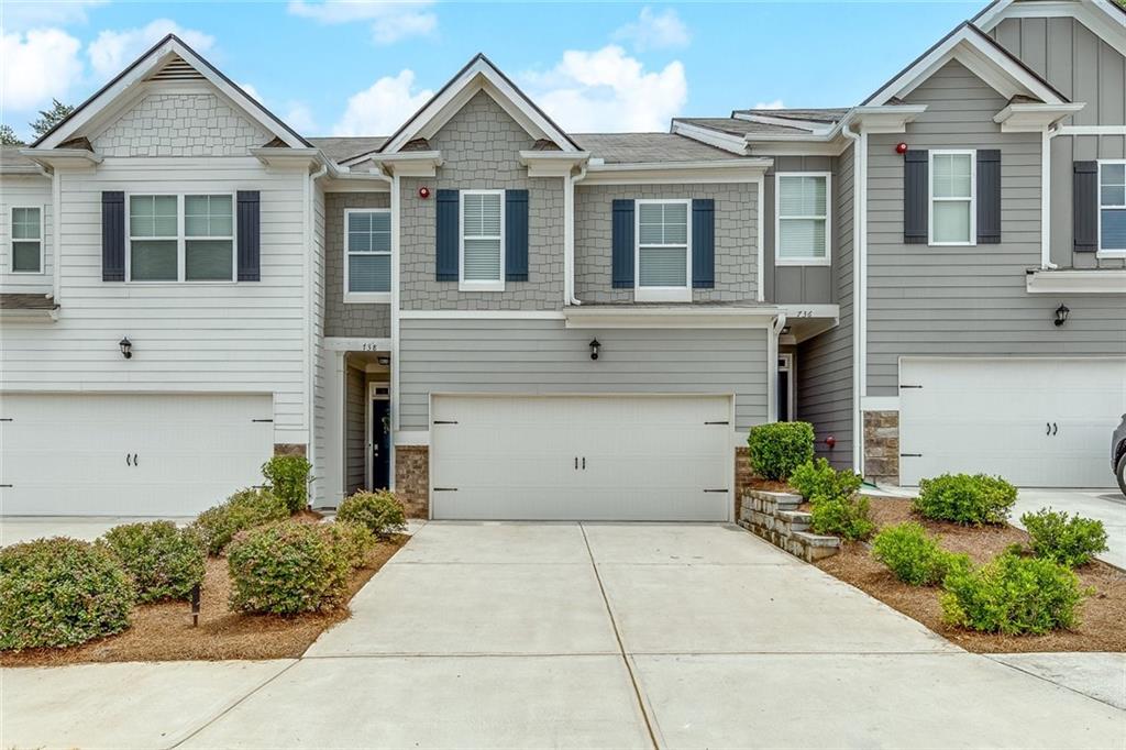 This open floorplan townhome checks all the boxes. Less than 5 years young - LVT flooring throughout the main level - spacious kitchen with plenty of cabinetry, granite counters, large center island, recessed lighting, stainless steel appliances and view to the family room. Upstairs you will find an oversized primary bedroom with a spacious bathroom with walk-in shower, large tub, double vanity, large linen closet, and a large walk-in closet. Two additional bedrooms and another bathroom with double vanities. The backyard overlooks wooded area great for enjoying coffee or end of the day relaxation on the patio and is fenced in - 6ft privacy on the sides and wrought iron along the back - photos taken prior to fence being installed. Conveniently located near Downtown Woodstock, Roswell, major interstates, shopping, restaurants and more.