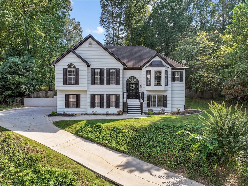 Prime location, stunning visuals, and a welcoming layout—this home is designed with first-time buyers and growing families in mind. Don’t miss your chance to see it quickly: it’s less than 6 minutes to downtown Woodstock, with easy access to premier shopping at the Outlet Shoppes of Atlanta, 575, top-rated dining, and highly regarded schools—perfect for busy mornings and family outings. The home greets you with a move-in ready feel, featuring high-end carpet, fresh paint, and durable flooring throughout. An open-concept living space with dramatic vaulted ceilings welcomes abundant natural light, creating a bright, cheerful atmosphere for everyday life, playdates, and entertaining. The fireside living room adds a cozy touch for winding down after busy days. In the kitchen, you’ll find stainless steel appliances, upgraded granite countertops, newer lighting, and stylish luxury vinyl plank flooring, with a cheery breakfast area that flows into the entertaining space and formal dining room—ideal for family dinners and celebrations. A partially finished terrace level offers extra space that can function as a play area, a home office, or an additional bedroom, future-proofing the home as your needs grow. The primary suite features trey ceilings and a private ensuite with double vanities and a garden tub—a personal retreat after busy days. Outside, a fully fenced yard with a wooded backdrop and a back deck provides privacy for outdoor meals, morning coffee, and kid-friendly gatherings. This home delivers comfort, practicality, and real value, with a flexible layout that grows with your family. If you’re a first-time buyer or a young family seeking a welcoming, low-stress start with room to grow, this property is a must-see. Schedule a tour today and picture your life here—where convenience, comfort, and community come together.