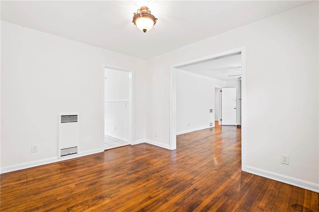 Empty room featuring hardwood / wood-style flooring and baseboards
