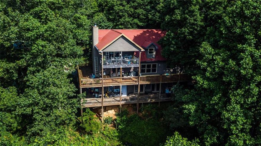 Welcome home to farmhouse/mountain cabin living with million dollar incredible views! You can be sure to enjoy views from every angle from either one of your two wrap-around porches or your private third covered porch from your master bedroom. This 5 bedroom, 4 full bath home has wood floors throughout the main floor and second story, the finished terrace level is all tile. On the main floor you walk into the family room with a fireplace that leads into the spacious kitchen showing off exposed wood beams, granite countertops, and a huge island which adds that extra room for cooking and entertaining. Continue through french doors that open into a separate dining room with walls of windows that immerse you into the forest and wildlife. Master on the main with full bathroom and jetted tub. Upstairs there is a landing with built-in bookshelves where you are able to look down into the kitchen below. Off of the landing there is a second master suite with a sitting area, fireplace, and your own private covered porch. The secondary bedroom is also upstairs with its private full bath as well. The terrace level features an in-law suite with 2 more bedrooms, full bath, den, huge storage space, and of course access to the wrap-around porch. Outside you have an open two car garage/workspace, a storage shed, horse barn, and chicken coup. From the driveway basically across the street there is a stocked community lake/pond for fishing. Endless possibilities await you with this beautiful property and still only 10 minutes from HWY 515.
