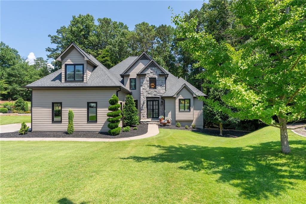 YEAR ROUND LAKE ACCESS - Have you been dreaming about more time on the lake, and less time spent on your to-do list? How about a paved cart path to the marina? Well call your movers because we’ve got the solution! This immaculate and lovingly maintained custom home has space for all (and you're going to need it once your friends hear you bought a lake house), countless upgrades and a private backyard that backs to Corp Property and Lake Allatoona! Gorgeous 2-story foyer greets you with newer marble and hickory hardwood floors, custom doors and iron railings, primary suite on main level with incredible views of the park-like backyard, bonus secondary suite and spacious bedrooms on the upper level, pristine, natural light-filled white kitchen with picture perfect views, and awesome entertaining deck are ready for you to move right in and start hosting the whole crew! Don't miss the screened porch off the kitchen and the full unfinished basement that's already framed and stubbed for you to finish exactly how you'd like, and there's even a workshop and outdoor shower for a cool rinse after a hot day on the lake! Stunning new picture and casement windows throughout, newer tankless water heater, central vacuum system, upgraded insulation and Trane AC units, irrigation system, and easy, no maintenance lake access!! Load the cooler and take the exclusive paved cart path to the community dock at Victoria Marina for endless summer days and exceptional sunsets, without having to leave the neighborhood! Just imagine the lifelong memories you’ll make when you can hit the lake anytime you want!!