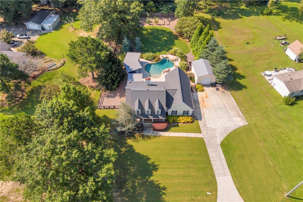 With easy access to Hwy 138 and I-20, this property is close to everything! It sits in the heart of Walnut Grove on a very private 1 acre. The home has been lovingly upgraded and features a split bedroom plan, island bar seating, wood shelved pantry, flex room, upgraded master bathroom, and eat in kitchen that leads to backyard paradise! The backyard includes an outdoor kitchen, half bath for pool guests, in ground pool with underwater stools and tanning shelf, garden area with raised beds, screened in porch with grilling station, covered back deck, firepit, and detached garage with so many uses!
