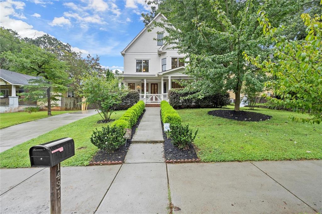 Stately 5 Bedroom/5.5 Bath move-in ready home with carriage house on a 66 x 200 lot on Metropolitan Avenue in the East Atlanta Village. Upon entering the home from the wrap-around front porch, you enter a great room with an open kitchen, dining area, breakfast area, large living space with a fireplace, and a large storage closet/pantry area. The main floor also includes a large bedroom with an ensuite bath, a 1/2 bath, and a covered rear porch. The second level has a rear yard facing primary suite with a balcony, primary bath with a large tiled shower, dual sink vanity, and an antique free-standing tub. The large walk-in closet has an additional opening into the laundry room. Two additional en-suite bedrooms complete the second level. The third level has a large stand-up storage area and a fifth bedroom/studio space with an ensuite bath. Two rear patios and a finished carriage house with a two-car garage complete this walkable home in the Burgess-Peterson School District.