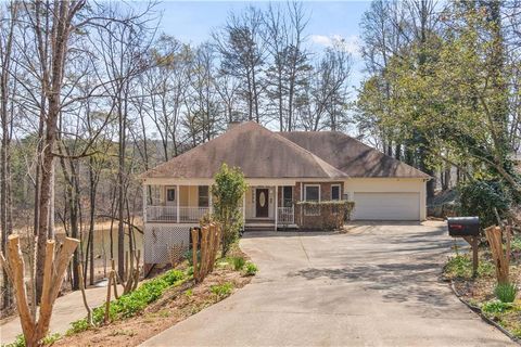 Single-family residence for sale at 6982 Dee Lane, Murrayville, GA, featuring a spacious driveway, serene wooded surroundings, and a porch, ideal for lakefront living near Lake Lanier.