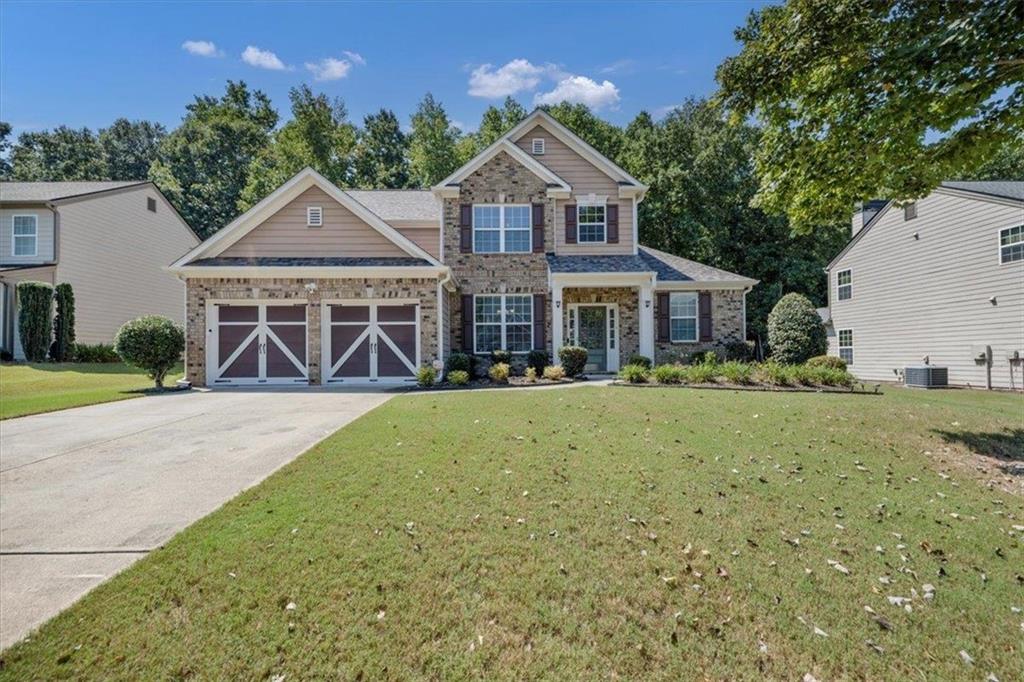 Beautifully maintained Craftsman-style home located in the highly sought-after West Forsyth area! This spacious home features a main-level primary suite with a large walk-in closet and a luxurious ensuite bath complete with double vanity, soaking tub, and separate shower. The open-concept main living area is filled with natural light and includes a cozy fireplace, a bright sunroom, and a modern kitchen with granite countertops and stainless steel appliances. Upstairs, you’ll find three generously sized bedrooms and two full bathrooms, offering plenty of space for family or guests. Enjoy relaxing or entertaining outdoors on the covered patio. Perfectly located near top-rated schools, shopping, dining, and grocery stores — this home offers comfort, style, and convenience in one perfect package!